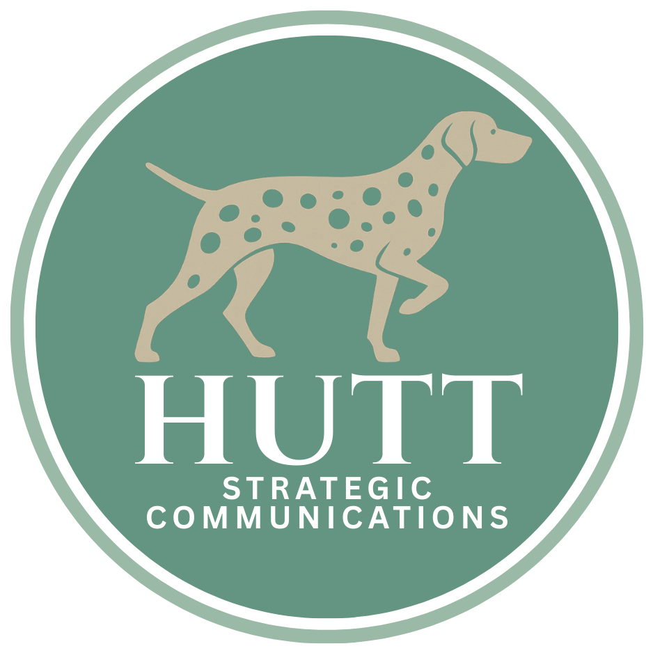 A logo featuring a dog with spots inside a circle, with the text "HUTT STRATEGIC COMMUNICATIONS" below.