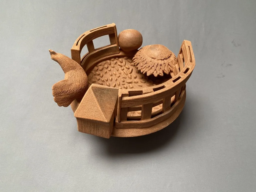 Small wooden basket containing various small wooden objects, including a spherical piece, a textured round piece, a cone, and a semi-circular piece with slits.
