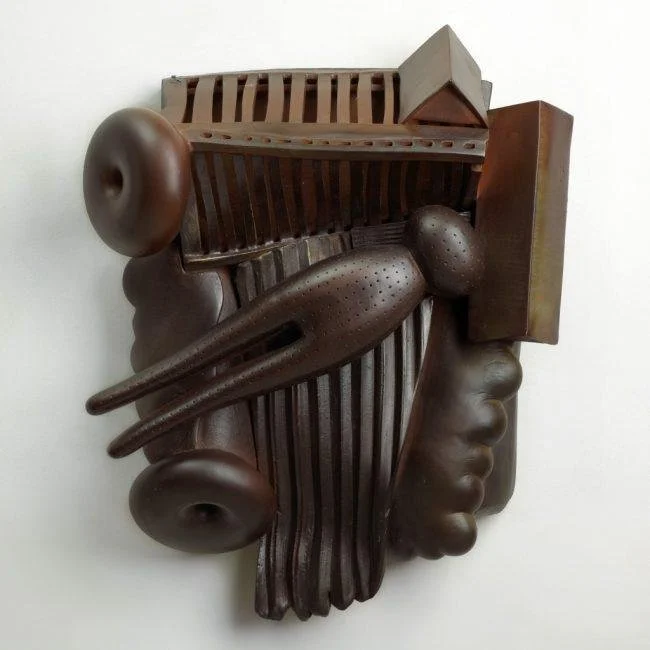 Abstract wooden sculpture with organic shapes and geometric patterns.