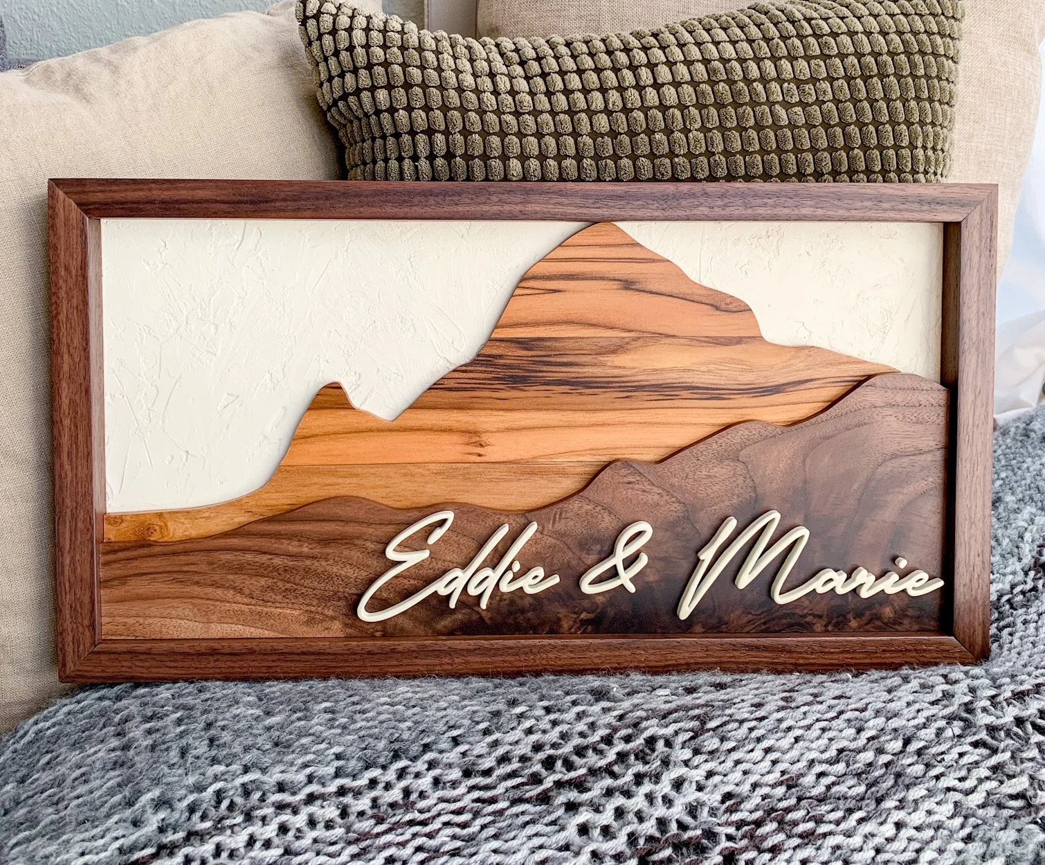 Wooden framed decorative artwork featuring mountain silhouette with the names Eddie & Marie in cursive lettering.