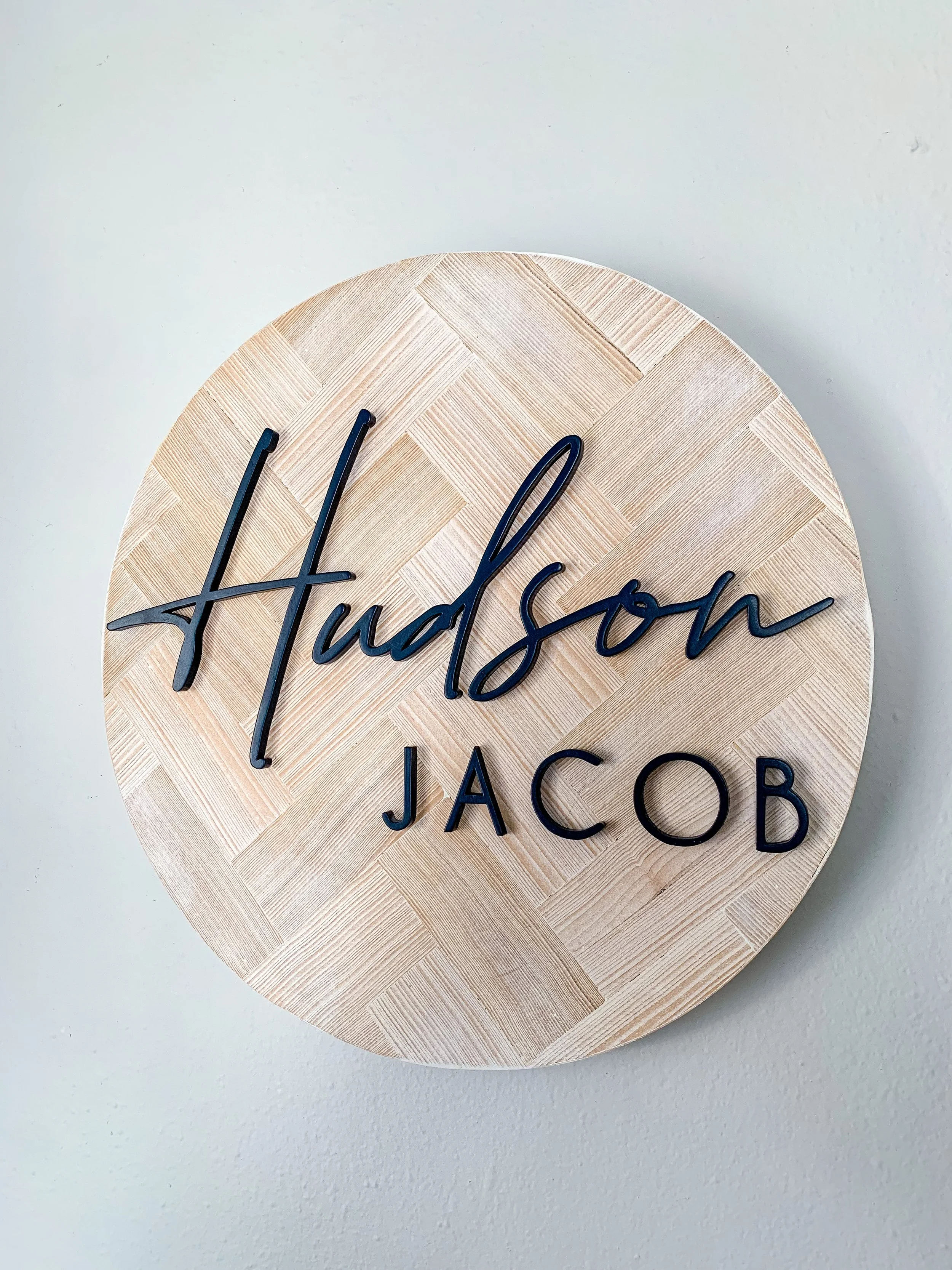 Wooden wall decor with black cursive and block letters.