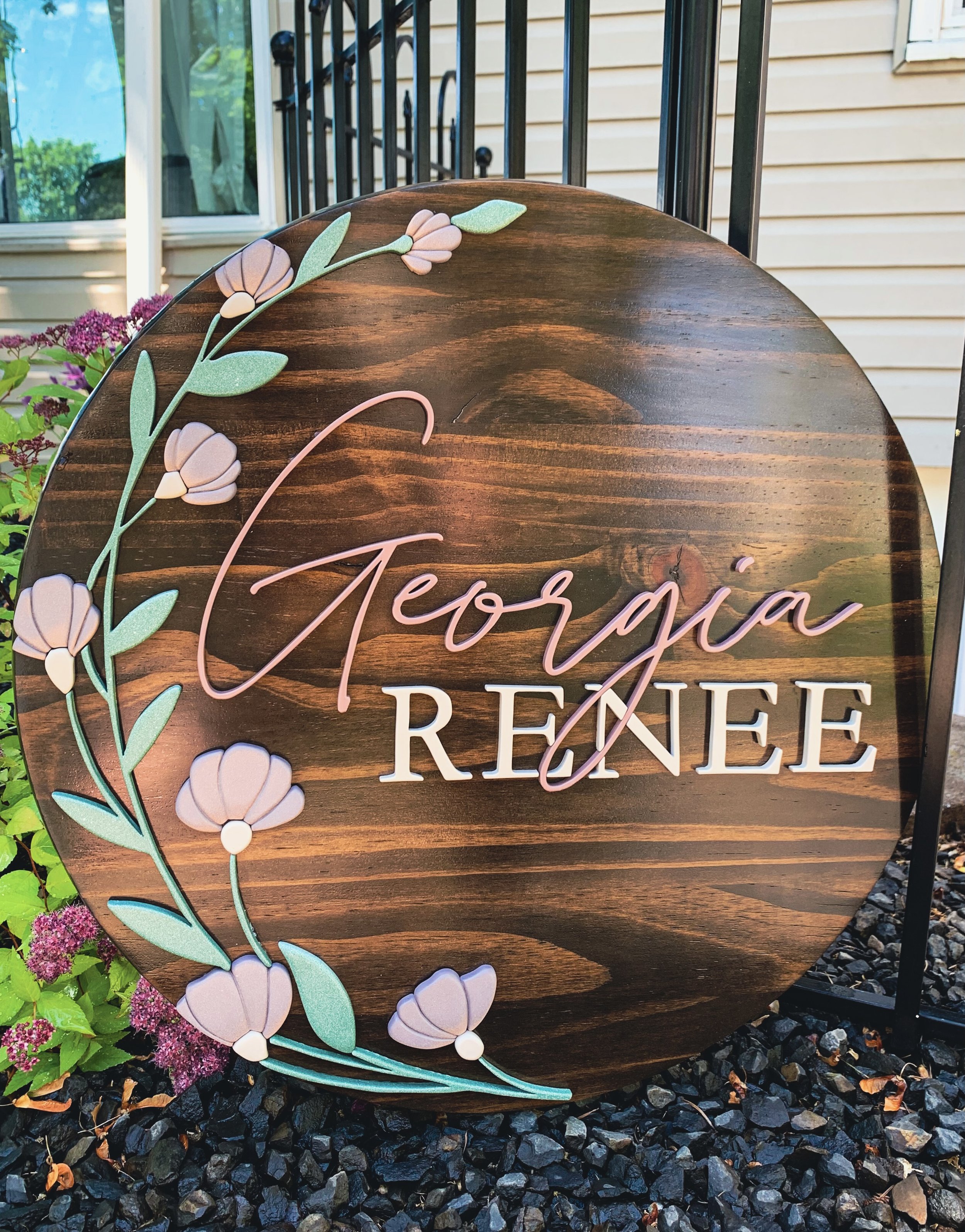 Wooden children name sign with floral decorations.