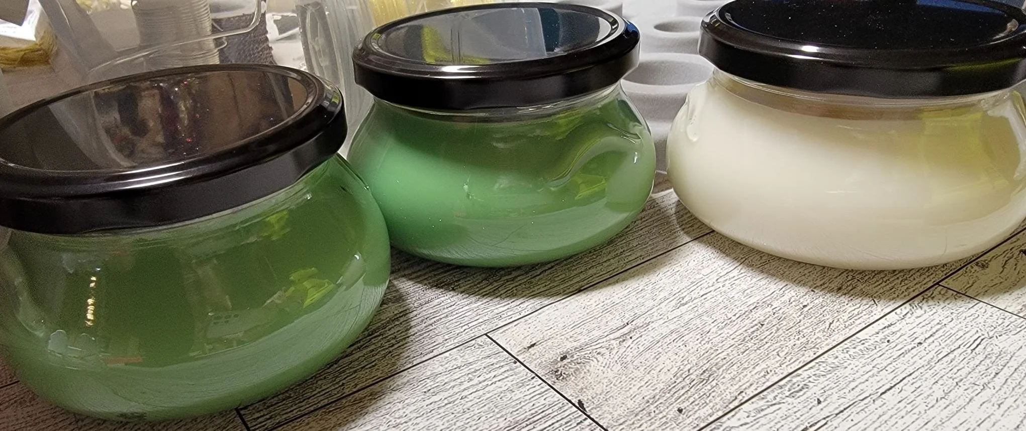 Handmade soy candle in a green jar with black lid — a quiet offering of warmth and intention.