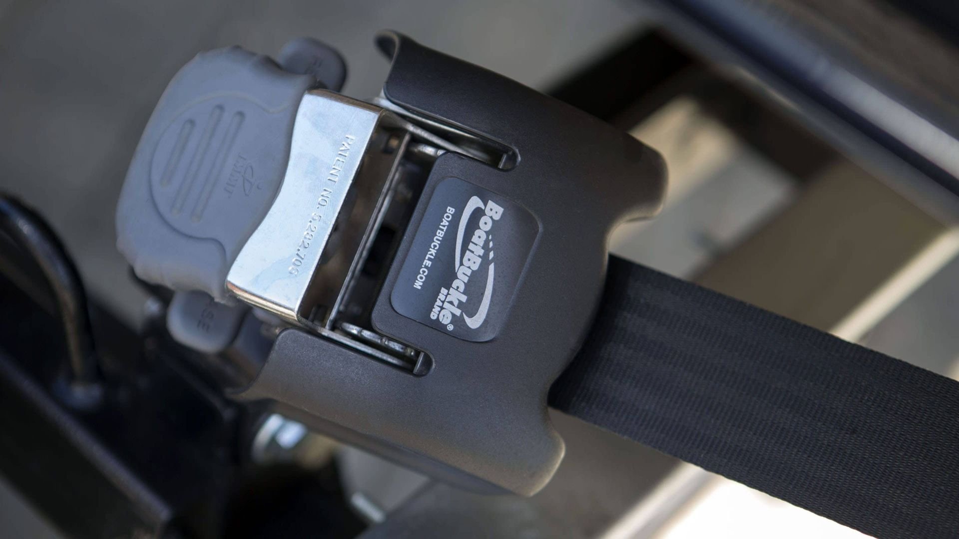 Close-up of a black safety belt buckle with a blue label that reads 'BooBoo Click' and 'www.BOTBUCKLE.com,' attached to a black strap.