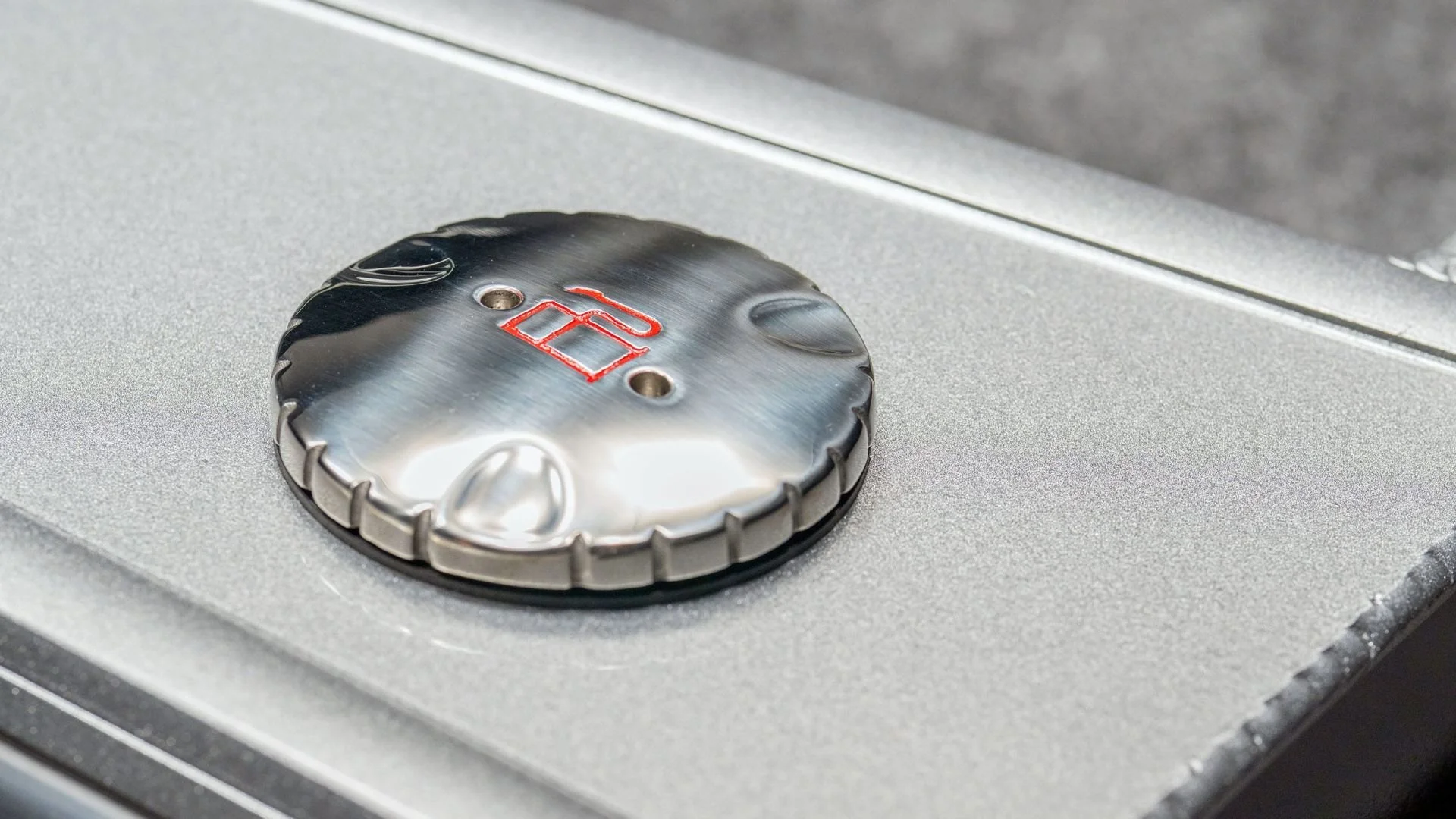 Close-up of a metallic lock dial with red markings on a silver surface.