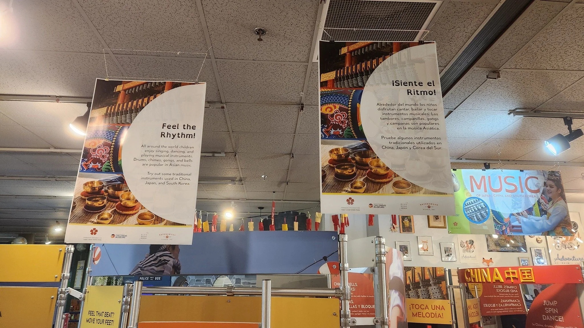 Banners hanging from a ceiling describing the Music of Asia exhibit.