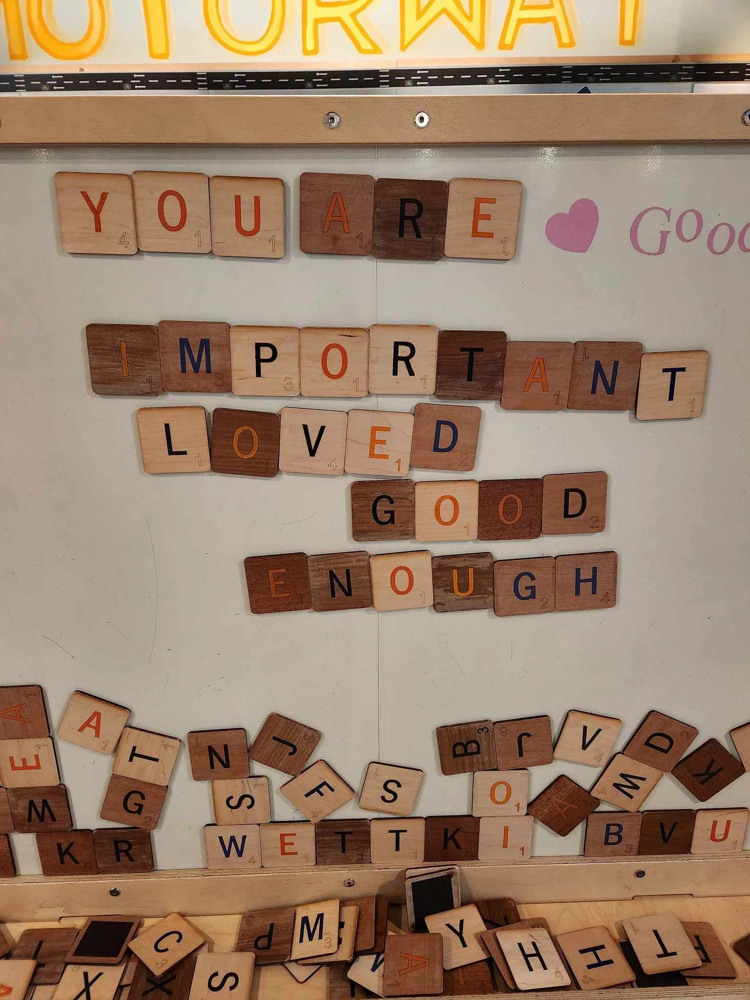 A whiteboard with giant Scrabble-like tiles magnetically stuck to the board. The words "You are important" are spelled out using the tiles.