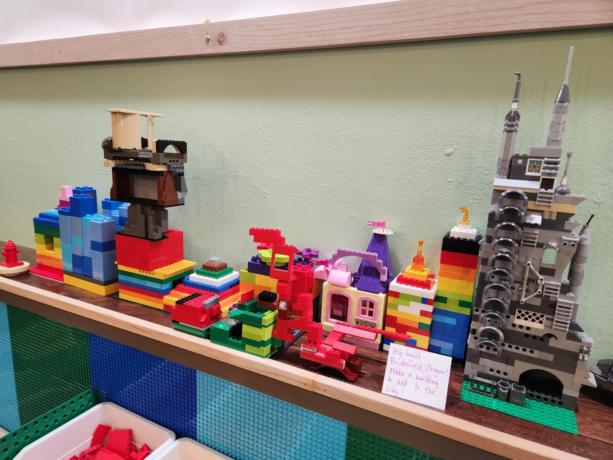 A shelf displaying Lego creations at the Bricksfield, Oregon exhibit. The Lego creations make a city.
