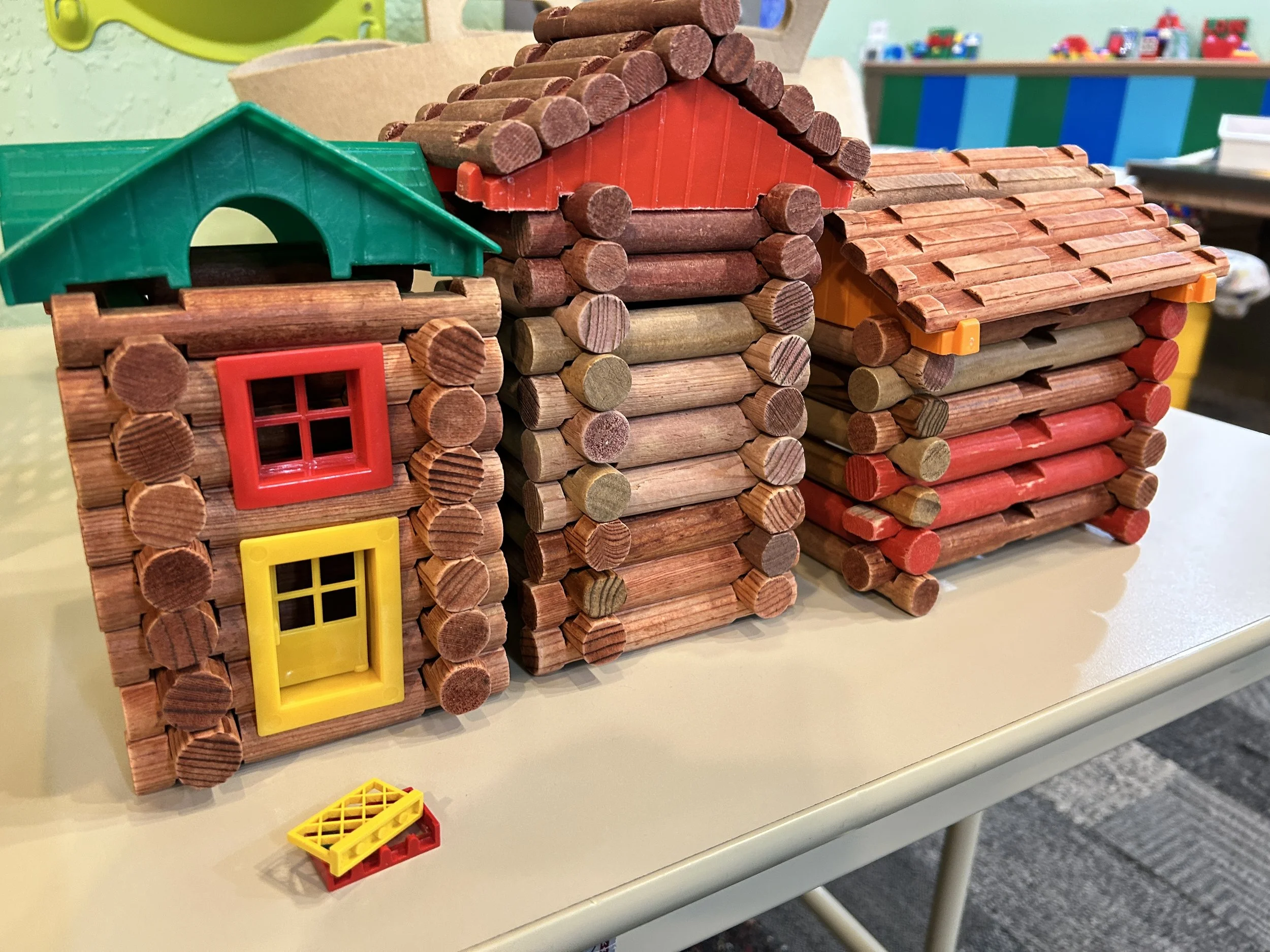 Three houses built out of Lincoln Logs.