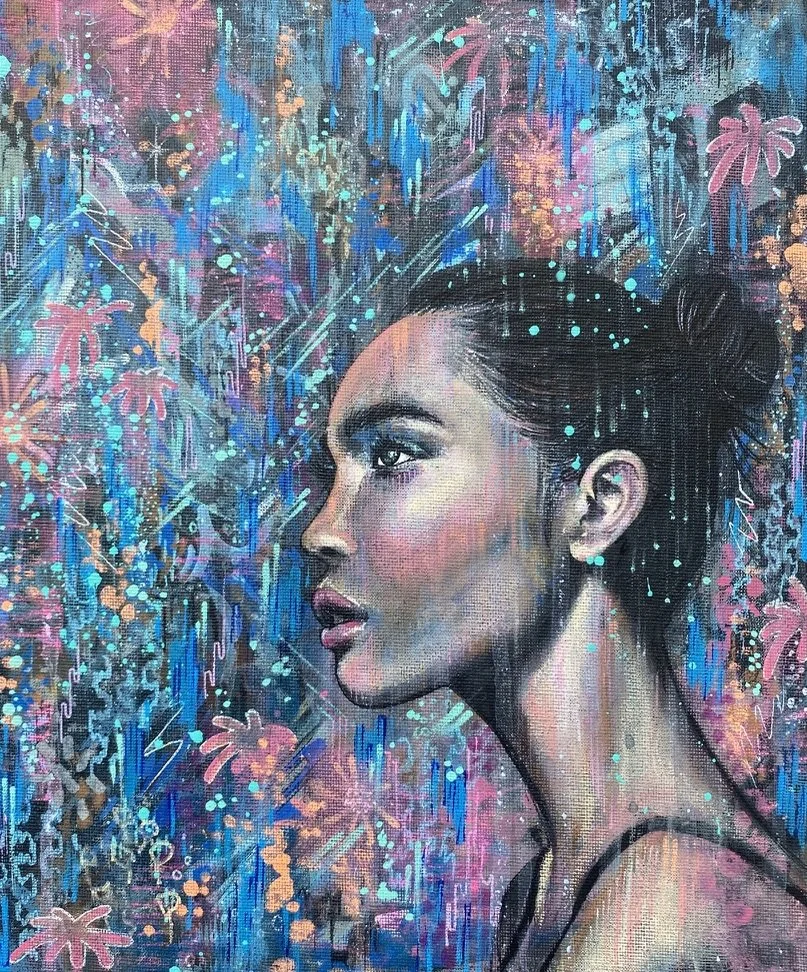 A colorful urban-style painting of a woman with dark hair in a bun, decorated with light blue dots, surrounded by vibrant abstract flowers and dripping paint in shades of pink, blue, and purple.