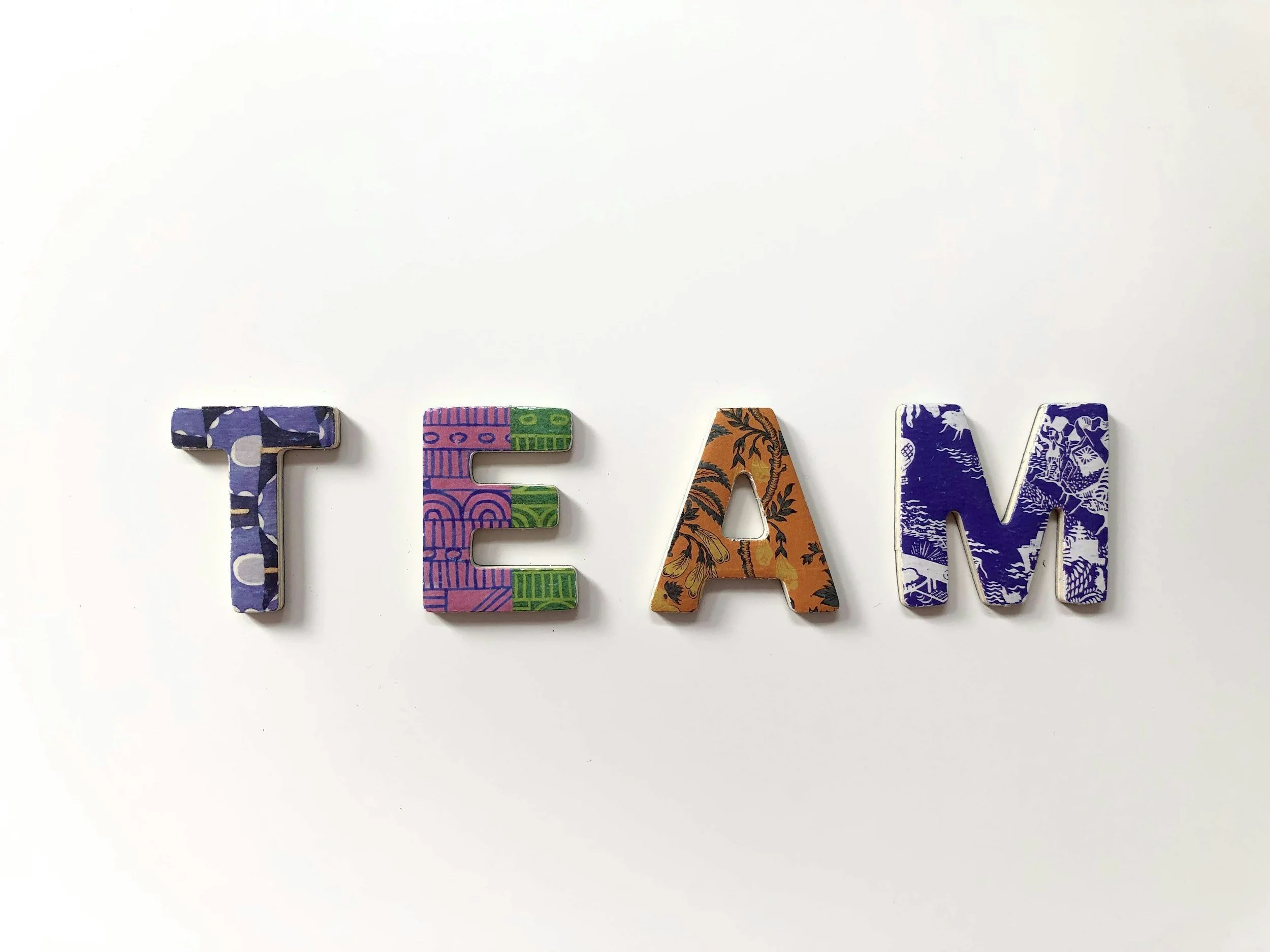 Colorful decorative letters spelling 'TEAM' on a white background.