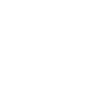 Silhouette of a person standing behind a podium with microphones.