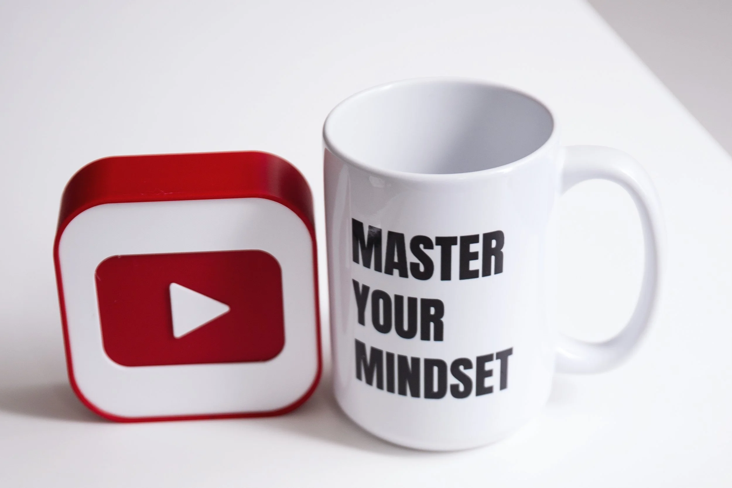 YouTube growth and mindset branding including mug with "Master Your Mindset" and YouTube play button.