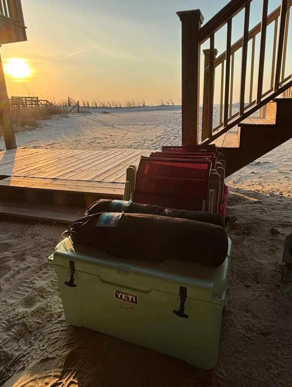 Beach chairs, cooler, and shibumi shade delivery to a rental home on folly beach with sunset in background