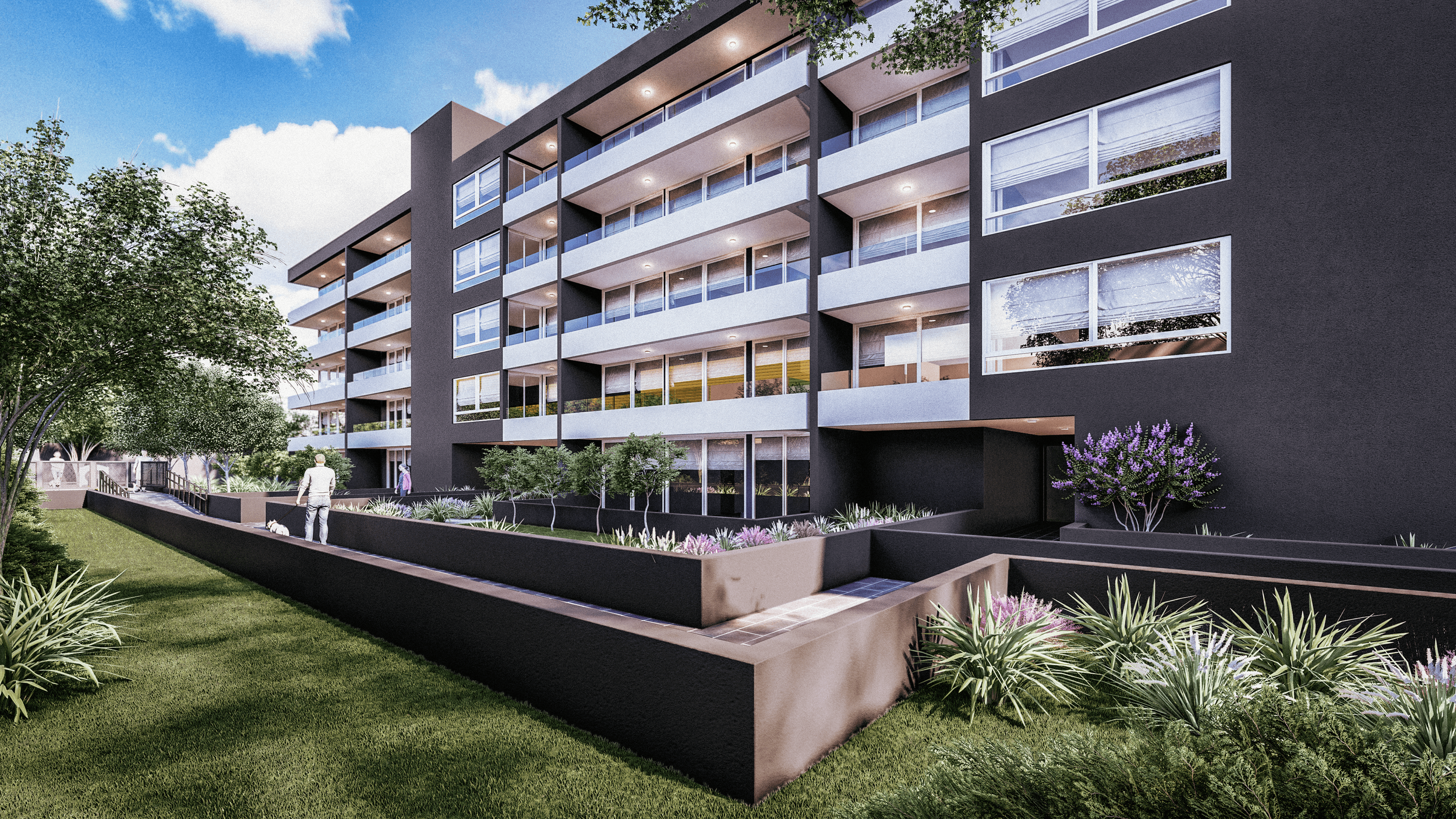 A modern multi-story apartment building with large glass windows and balconies, surrounded by landscaped garden with grass, trees, shrubs, and purple flowering plants.