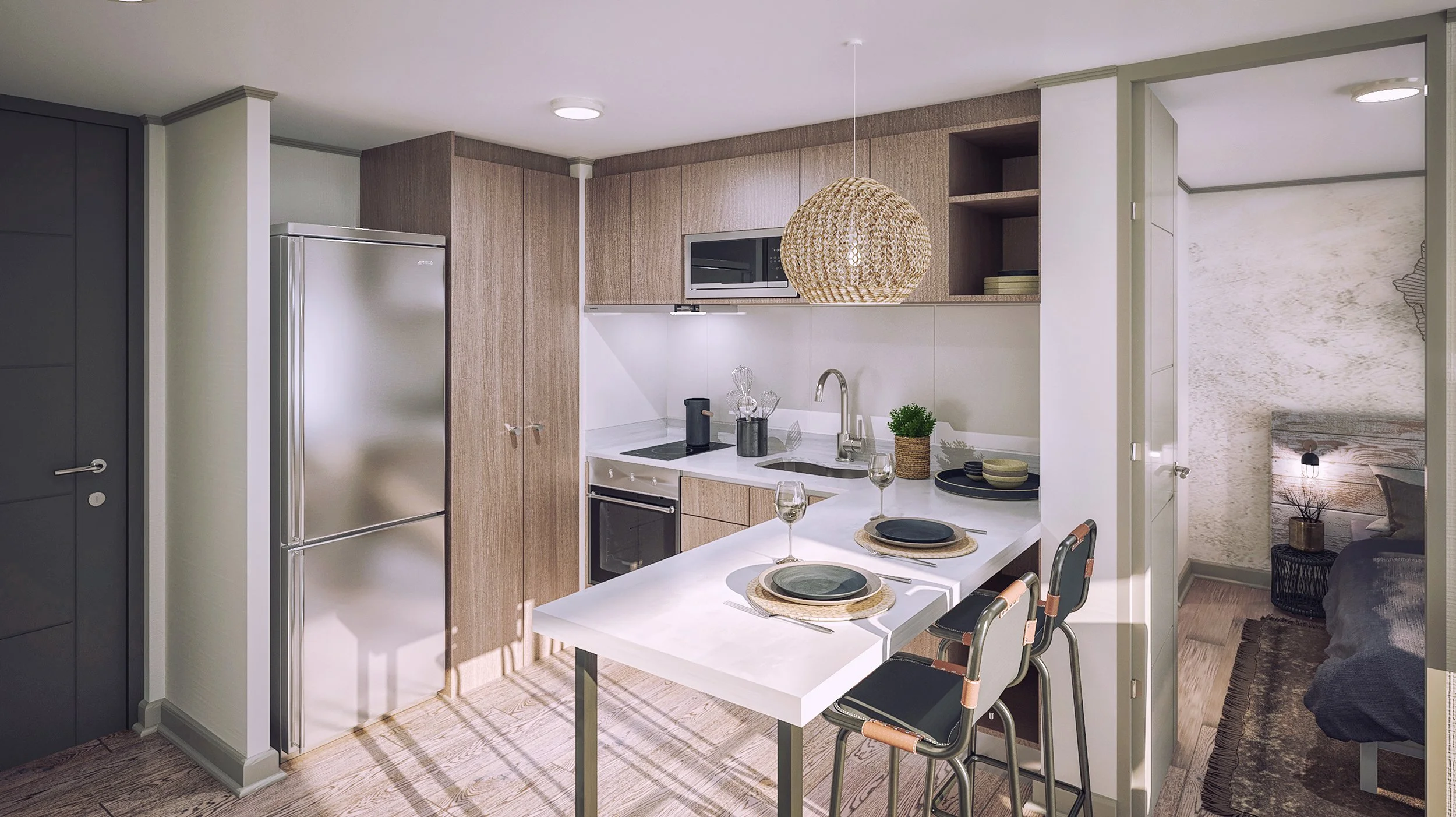Modern kitchen with fridge, microwave, white countertops, and open shelves, adjacent to a small dining area with three black chairs and place settings, and a view into a bedroom with a bed and nightstand.