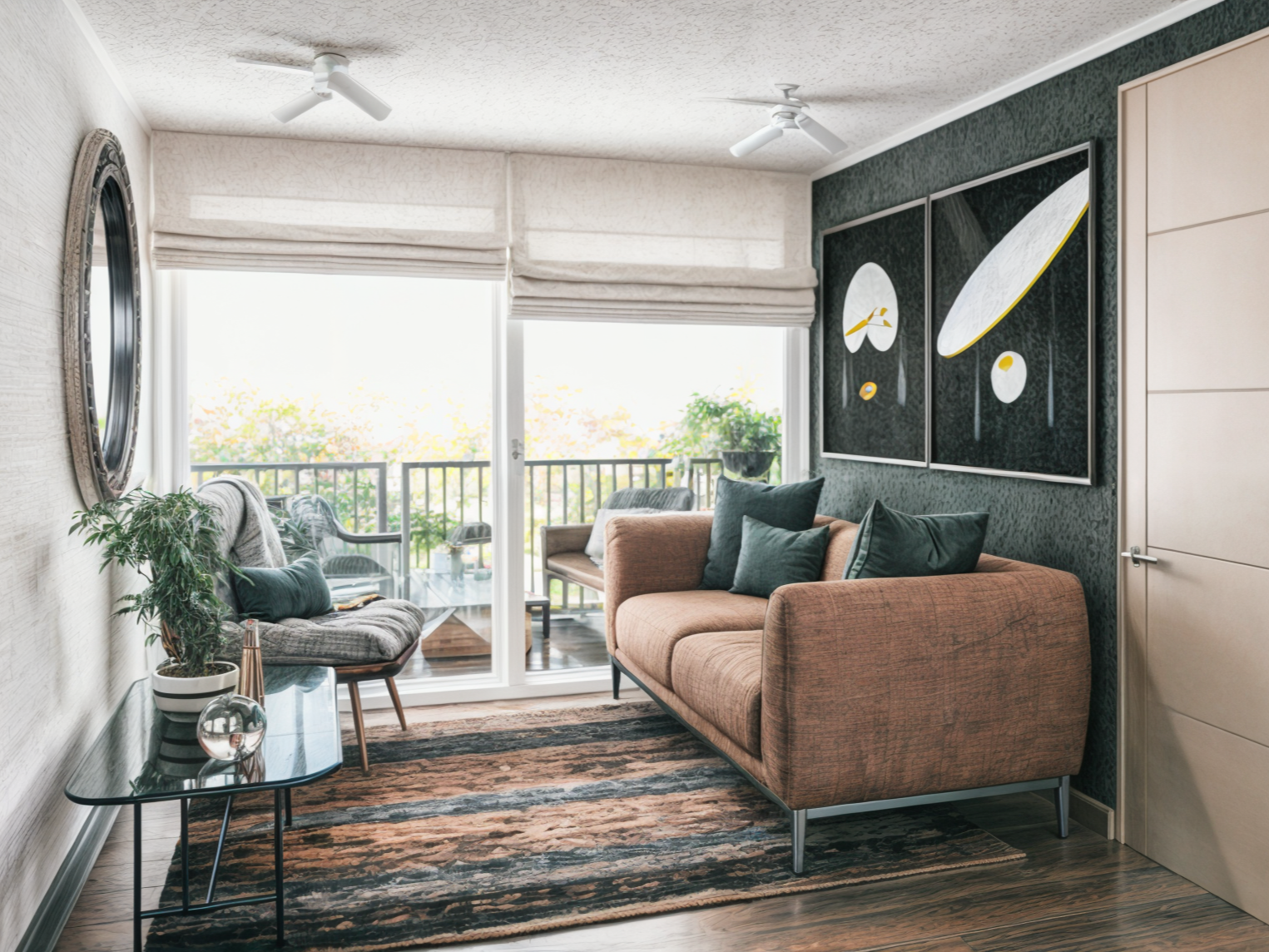 Living room with orange sofa, dark green pillows, wall art with black and yellow designs, large sliding glass door leading to balcony with outdoor furniture, potted plant, framed mirror, and ceiling fans.