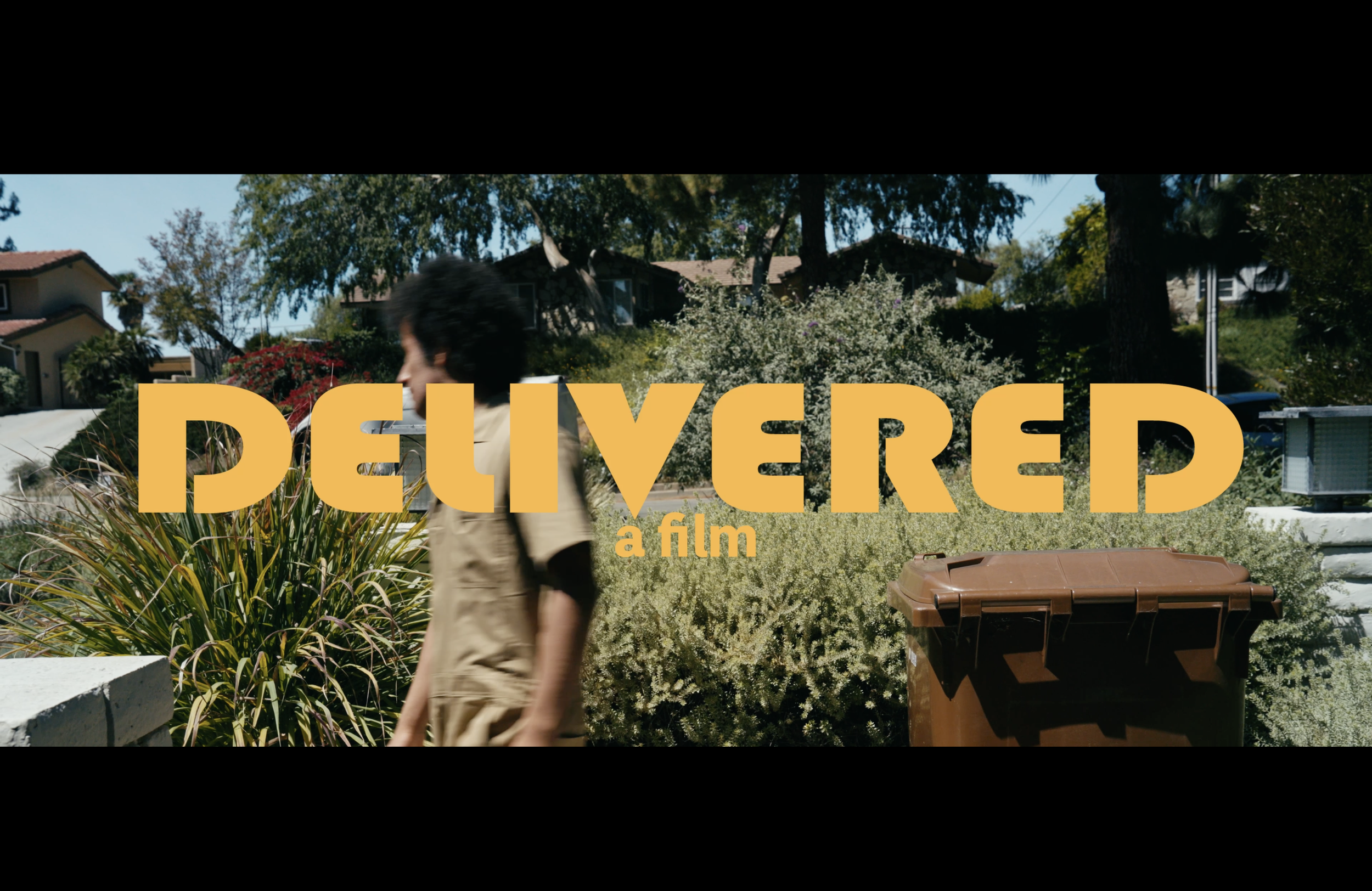 Film title card reading “DELIVERED a film” over a suburban scene with a person walking past a large trash bin.
