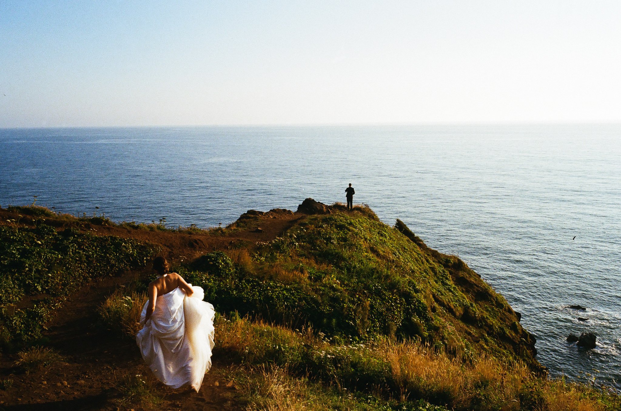 a bride walking to the groom at their first look on elk flats on the oregon coast for their elopement