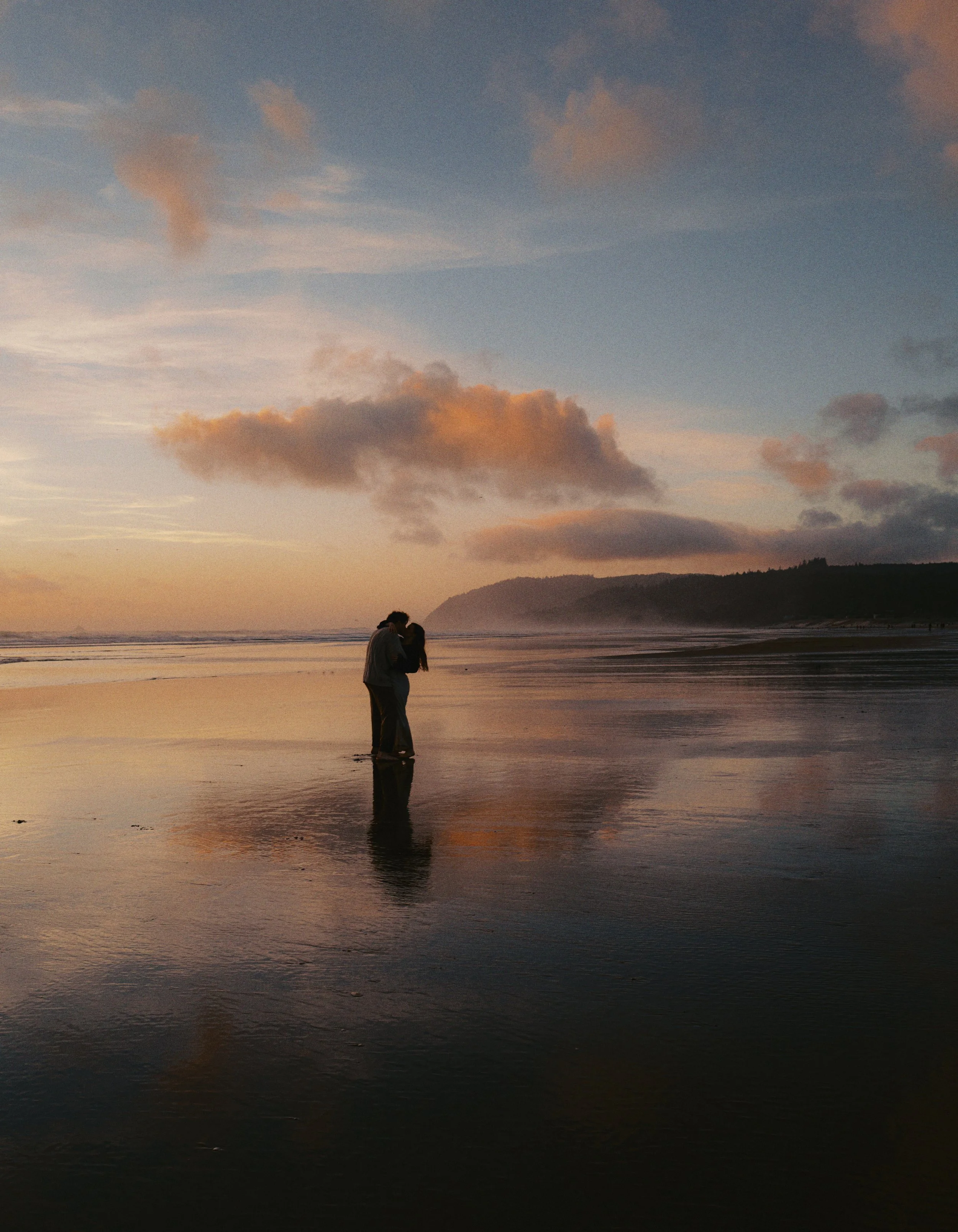 engaged couple dancing at sunset on the oregon coast on film
