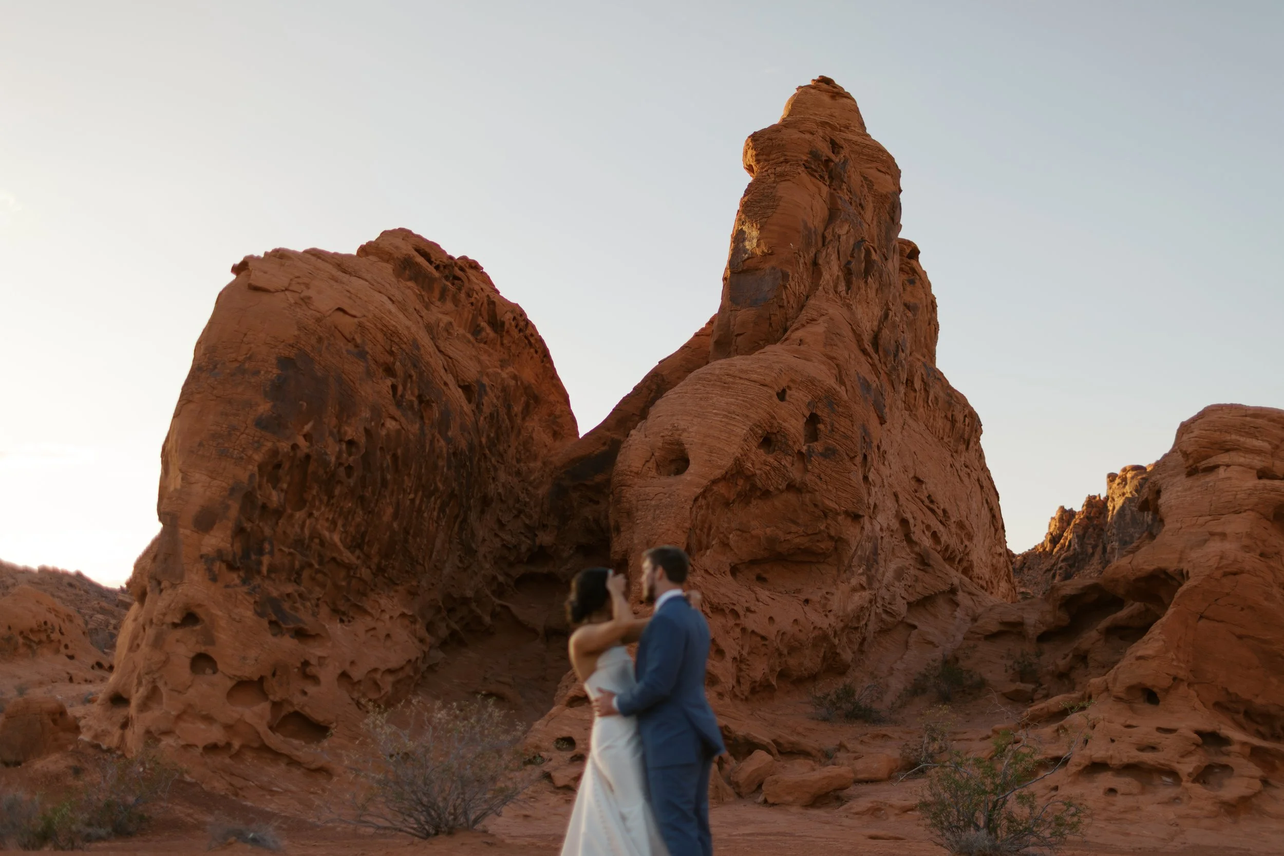 bride and groom on a final dance, with red rocks of valley of fire behind them