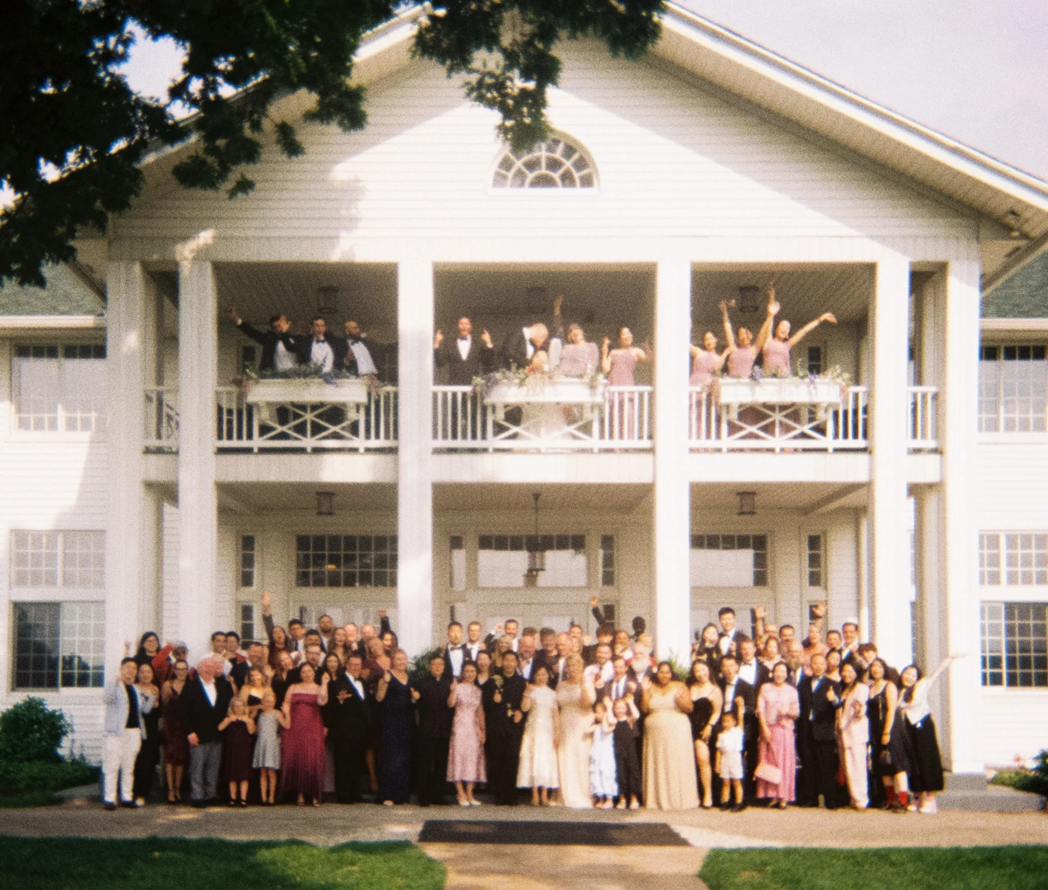 a family photo gather in front of a white estate in michigan