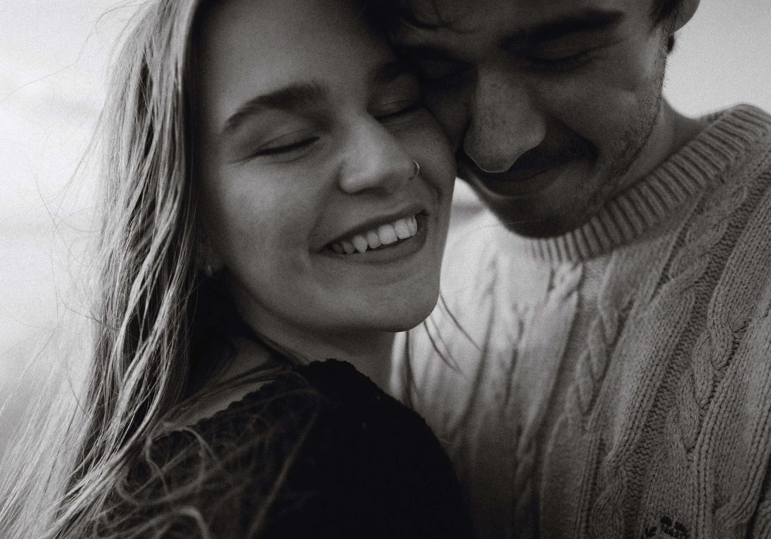 a closeup shot of a women holding a man and laughing, candid on film