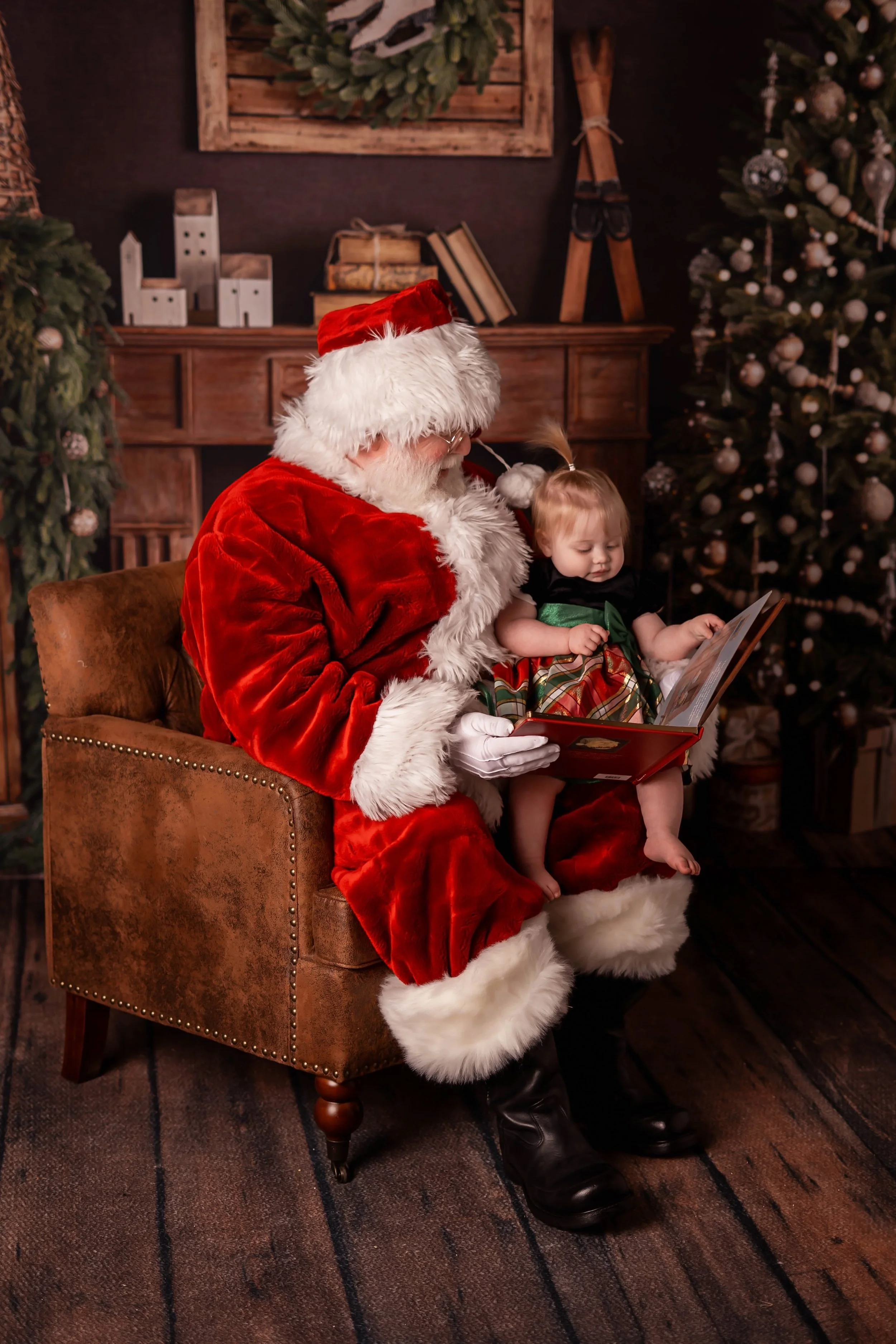 Santa Snow reading a book to a small child while seated in a chair.