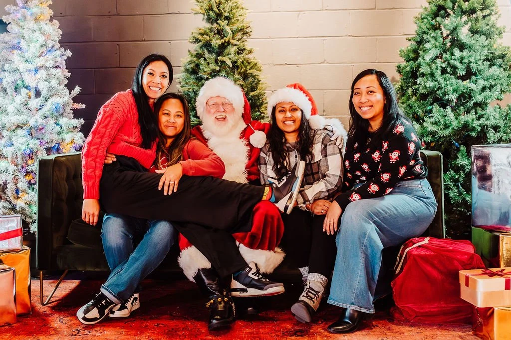 Santa Snow sits with the team from a community home builder at their customer appreciation Christmas Party
