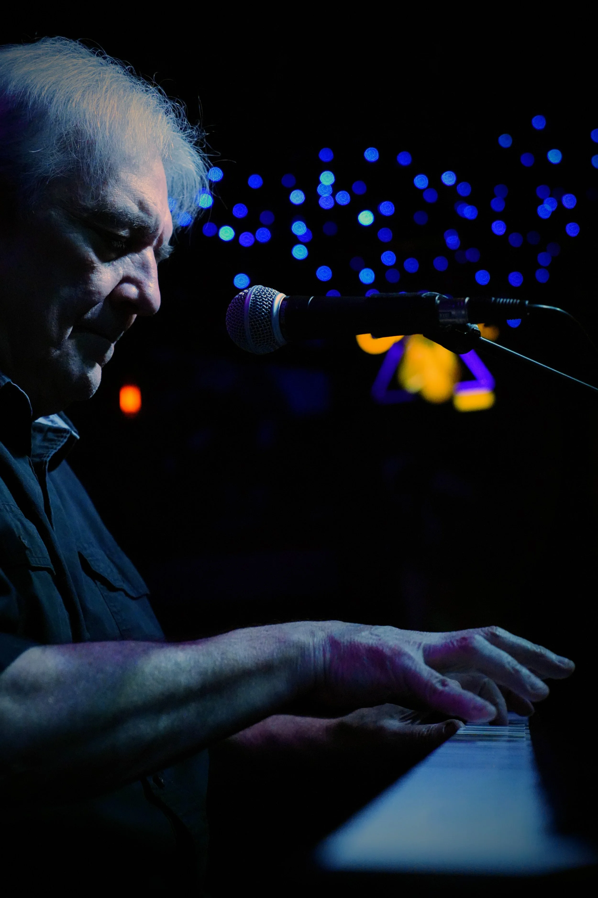 Charlie Cheesman of The Late Night Revalators performing on the blues piano under the glowing lights of the world-famous Slippery Noodle in Indianapolis.