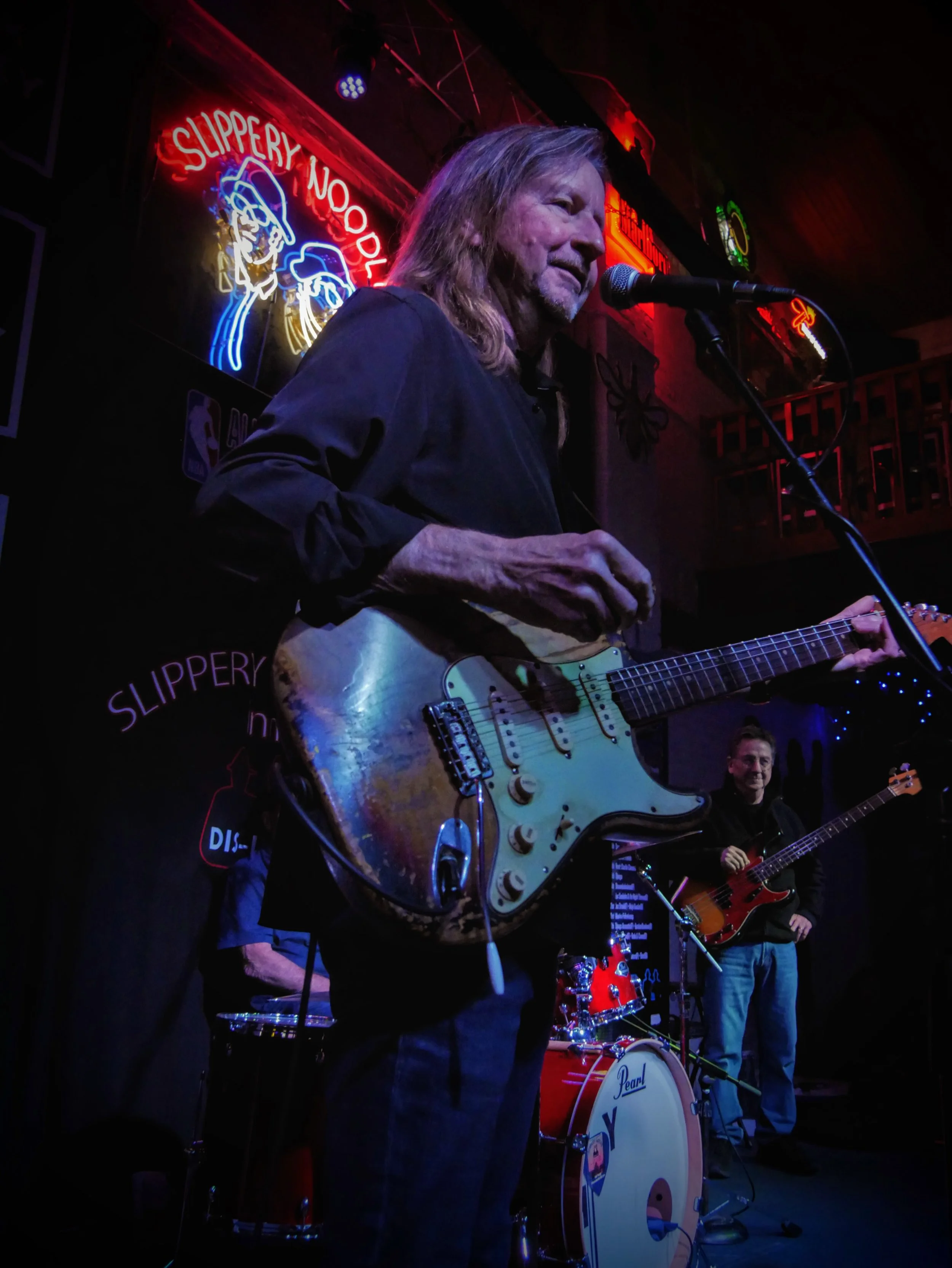 Gordon Bonham Jr., a world-class guitar player, performing on stage under the glowing lights of the world-famous Slippery Noodle in Indianapolis.
