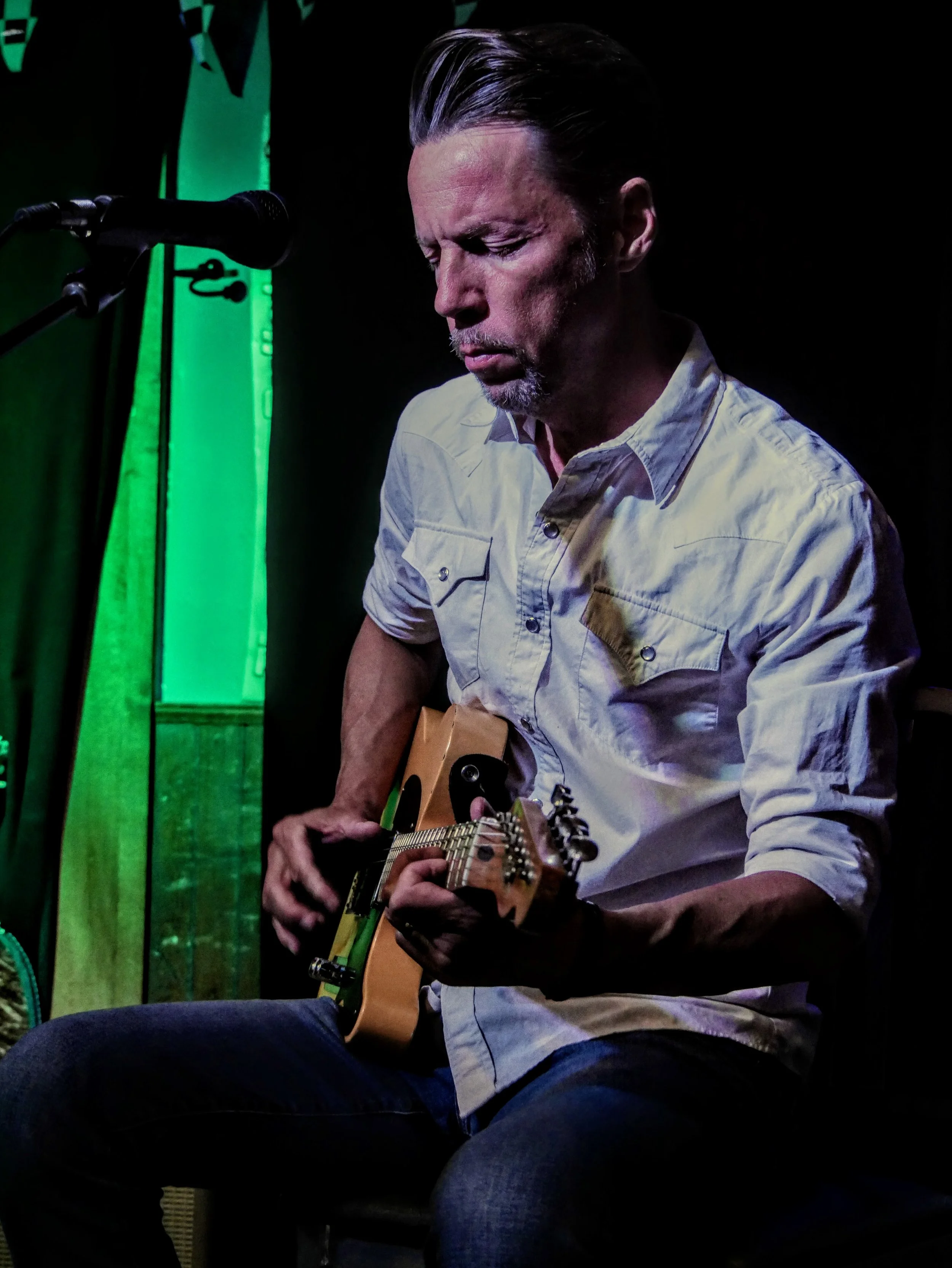 Paul Holdman, a world-class guitar player, performing under the glowing lights of the world-famous Slippery Noodle in Indianapolis.