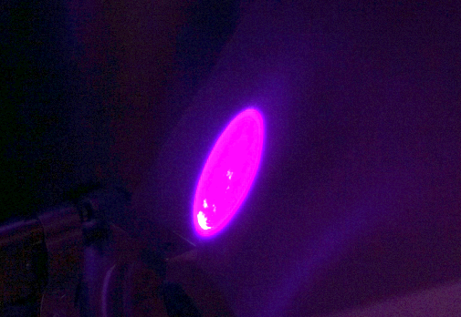 A laser beam on a paper card viewed through a laser beam viewer.