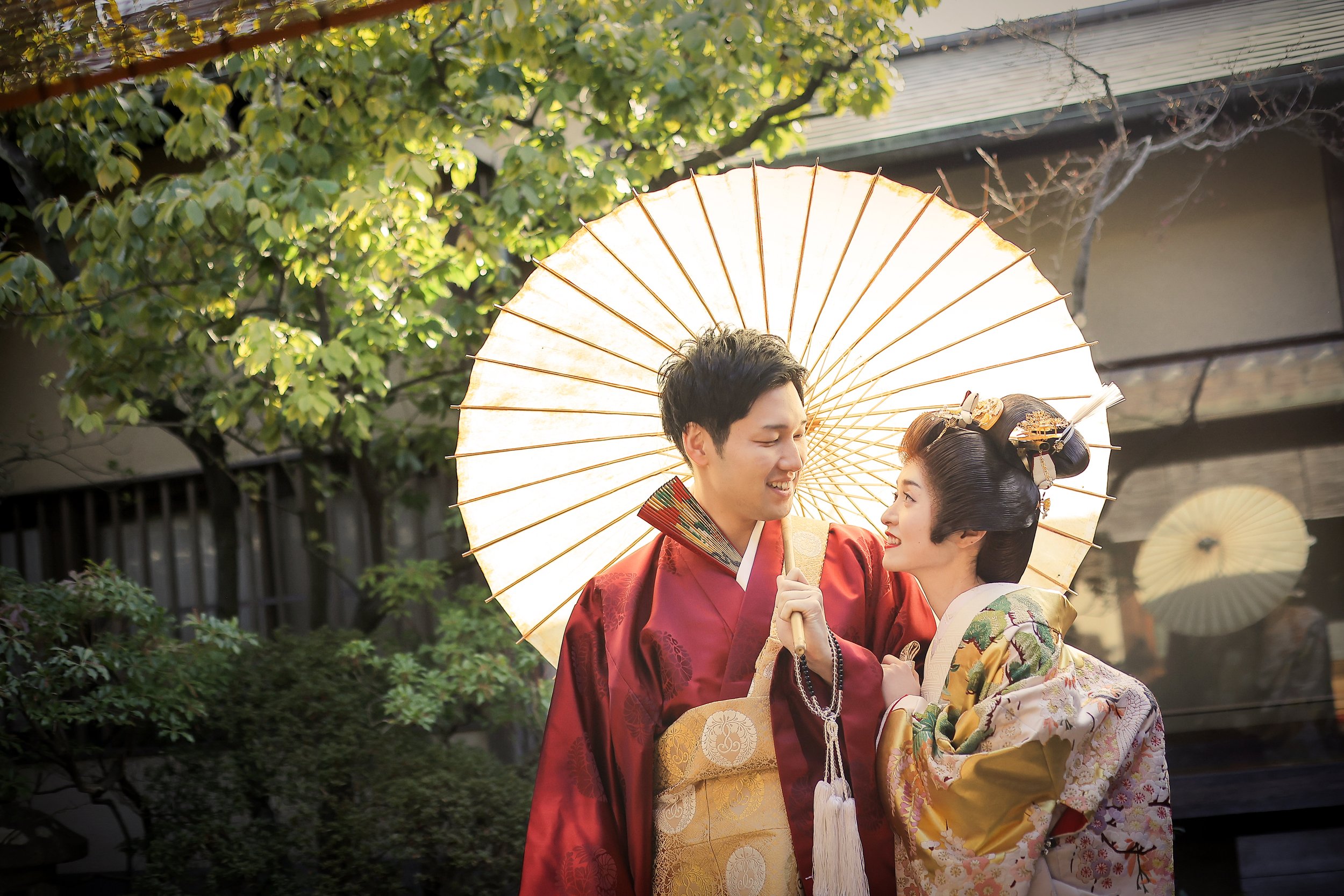 ロケ撮影イメージ｜悟道庵｜和装の新郎新婦が傘を持ち、笑顔で見つめ合っている写真