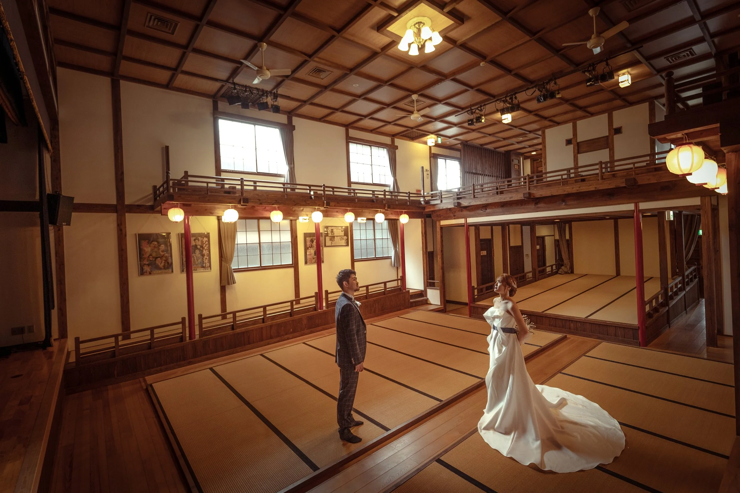 ロケ撮影イメージ | 御手洗町並み保存地区 | 歴史的建造物「乙女座」に立つふたり。男性はスーツ、女性は白いドレスを着ている。暖色の照明と伝統的な畳の床が特徴的。