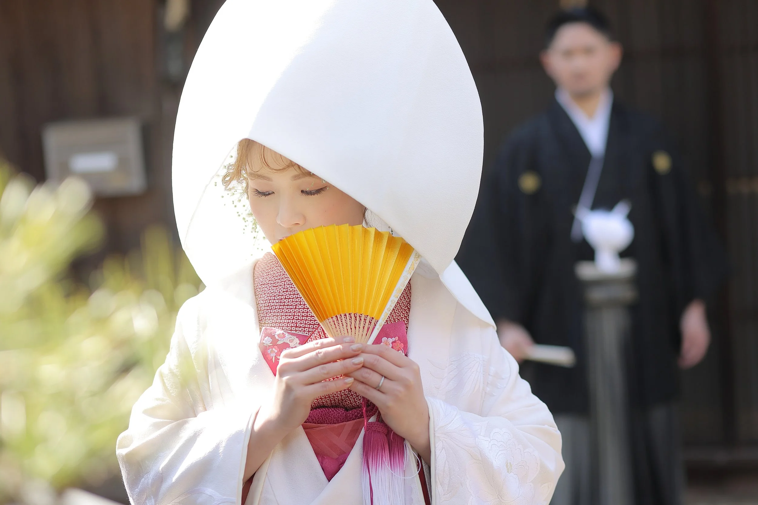ロケ撮影イメージ｜御手洗町並み保存地区｜綿帽子の新婦が目を閉じて祈っているようす。背景には新郎が立っている。