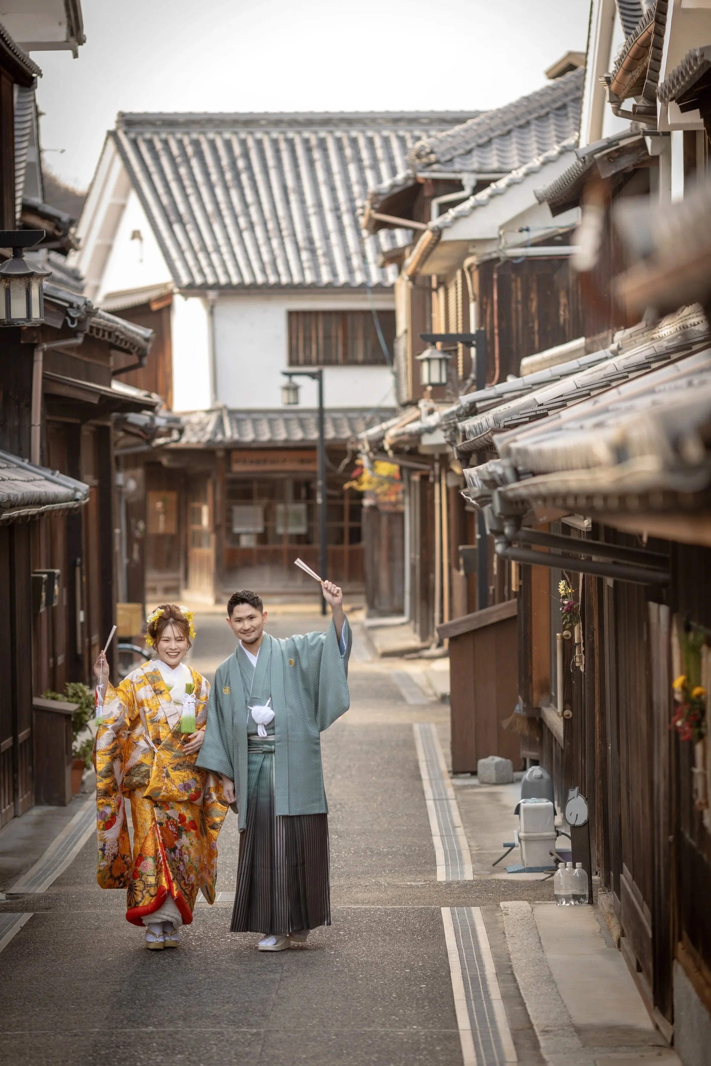 ロケ撮影イメージ｜御手洗町並み保存地区｜和装の新郎新婦が伝統的な町並みの通りで笑っている