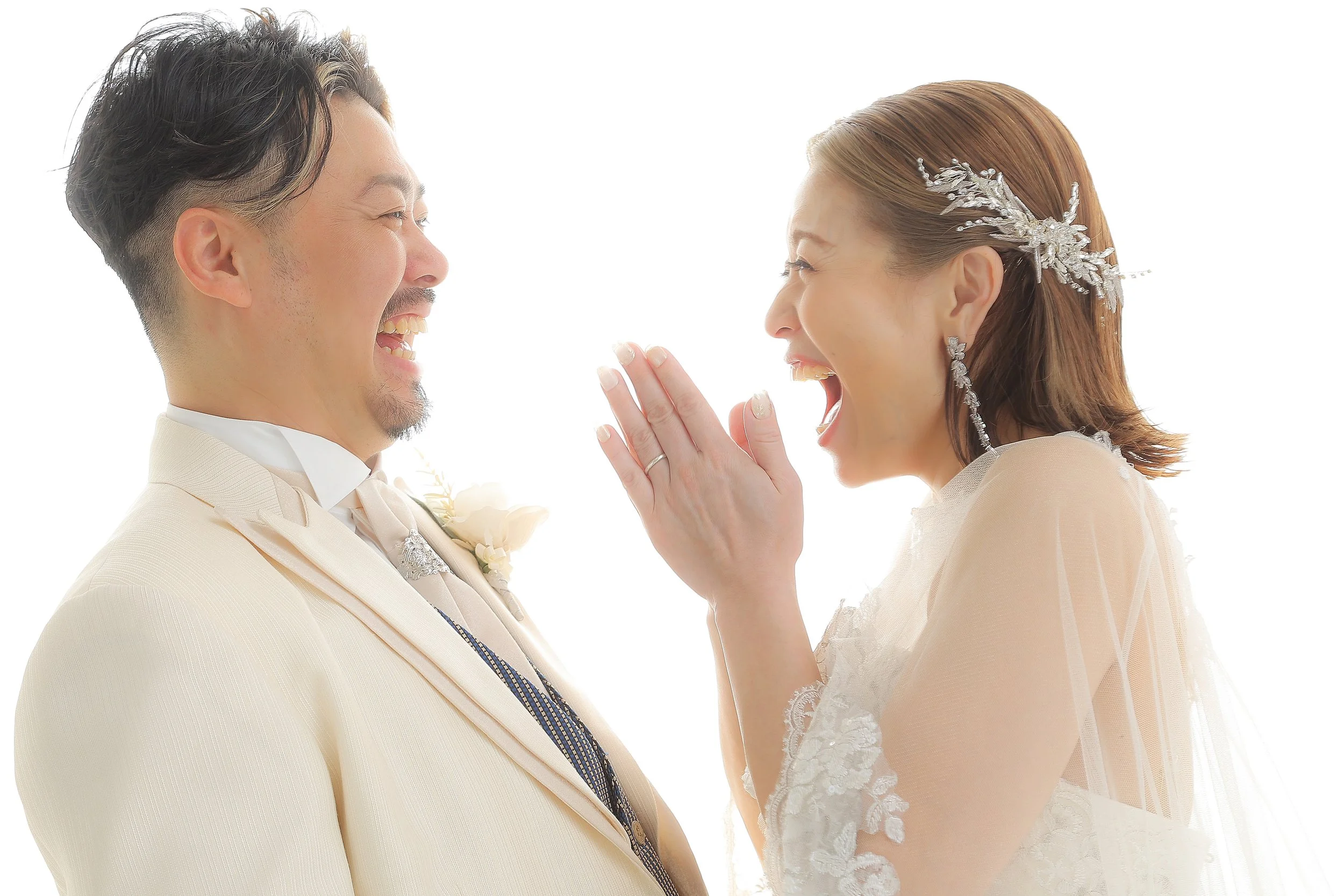 スタジオ撮影イメージ｜結婚式の新郎新婦が笑いながらお互いを見つめ合う