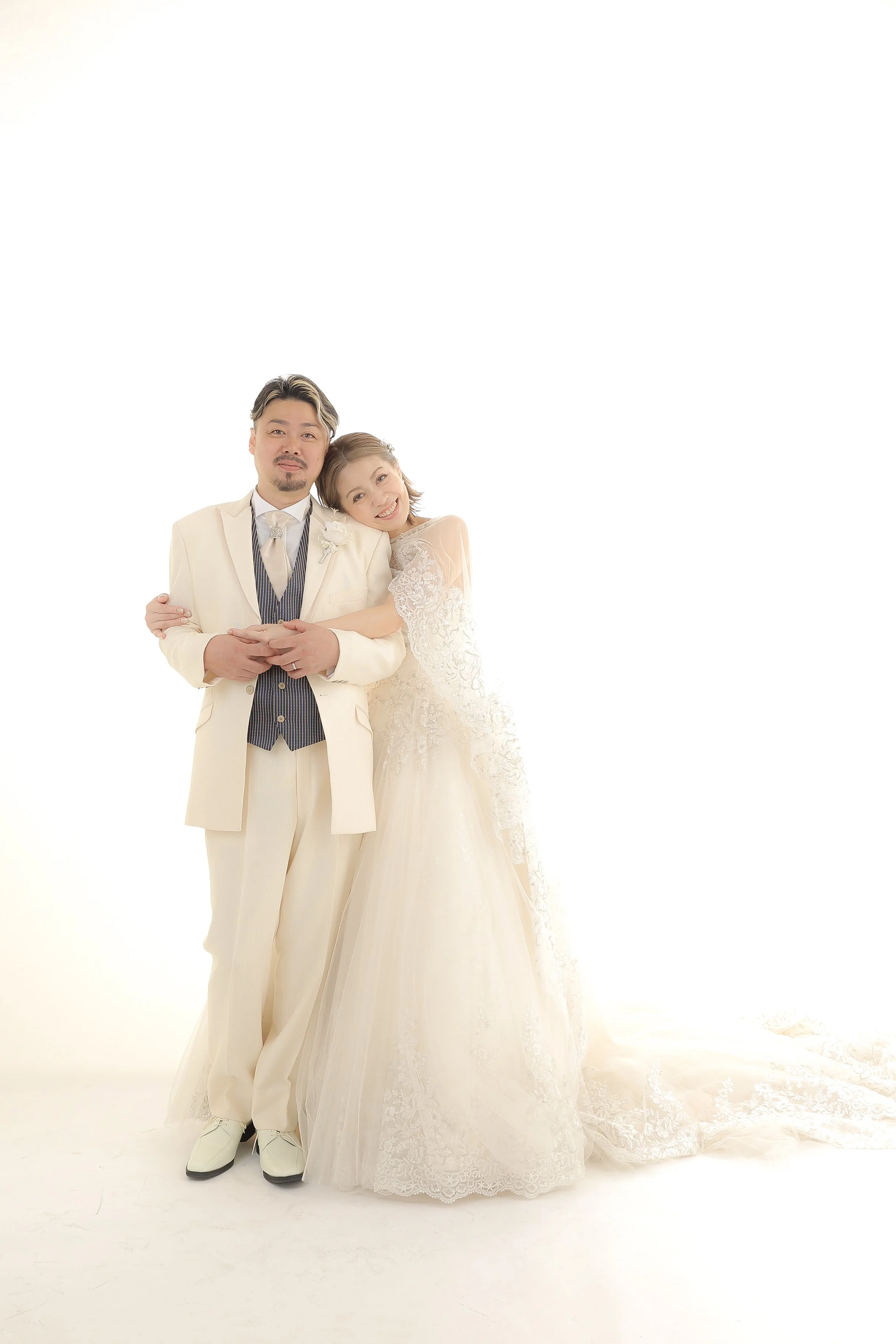 スタジオ撮影イメージ｜ウェディングドレスを着た花嫁とスーツを着た花婿が寄り添っている写真