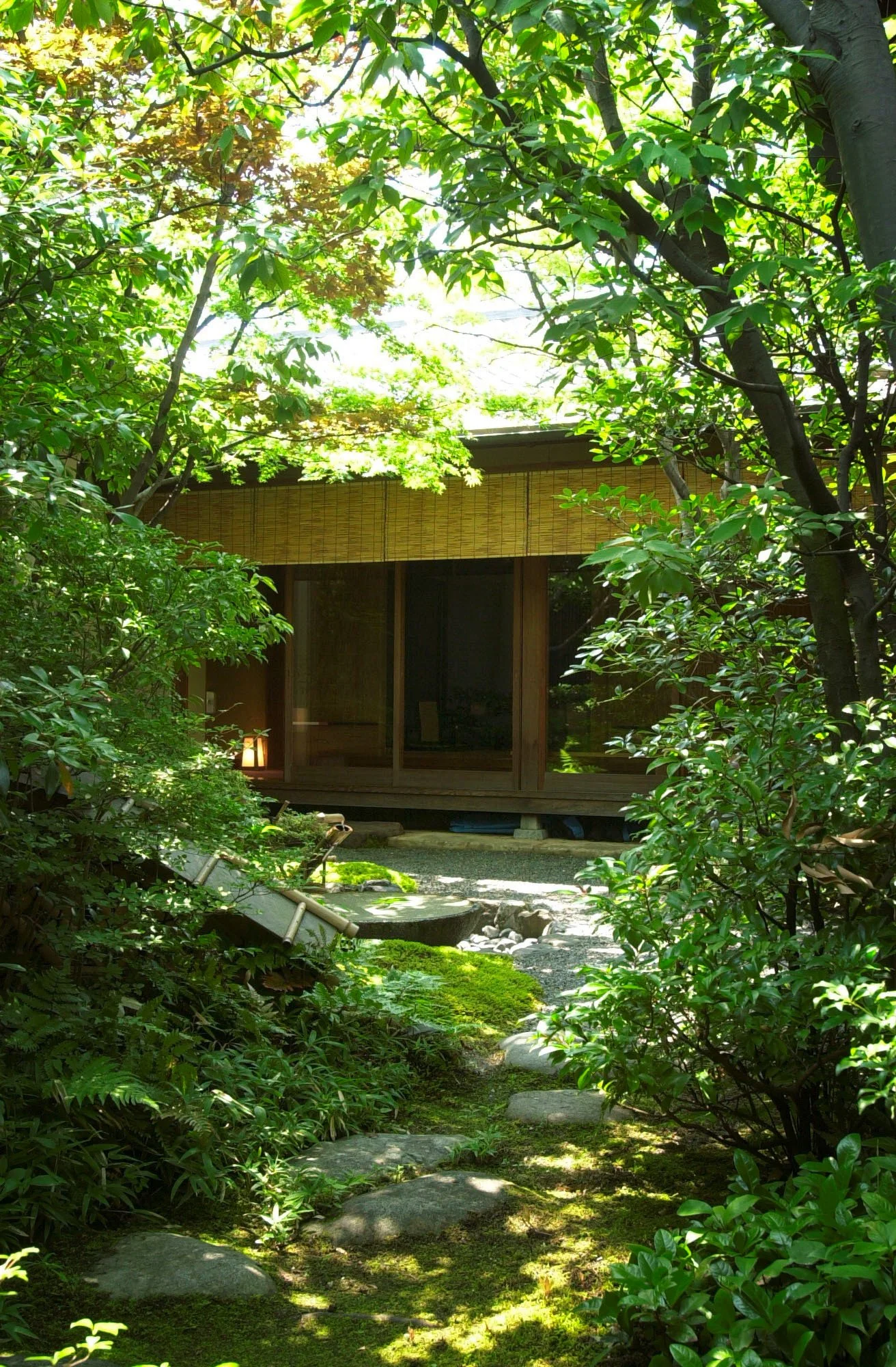 悟道庵点景 | 緑豊かな庭園の中に、木製の伝統的な日本家屋が見える。伴う石畳の散策路と緑の苔が敷き詰められ、自然の静寂さを感じさせる風景。