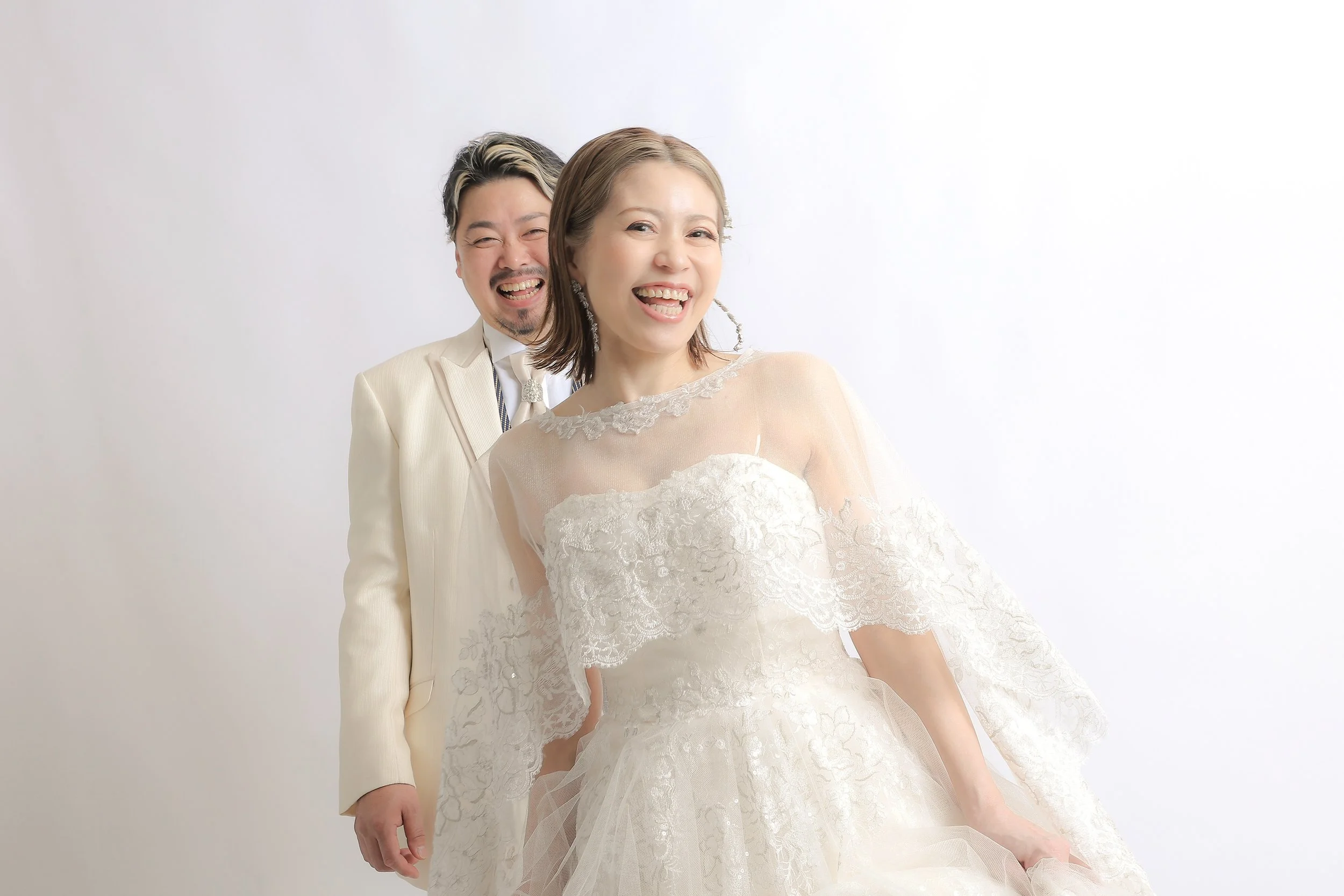 スタジオ撮影イメージ｜結婚式を挙げたカップルが笑顔でポーズを取る白背景の写真