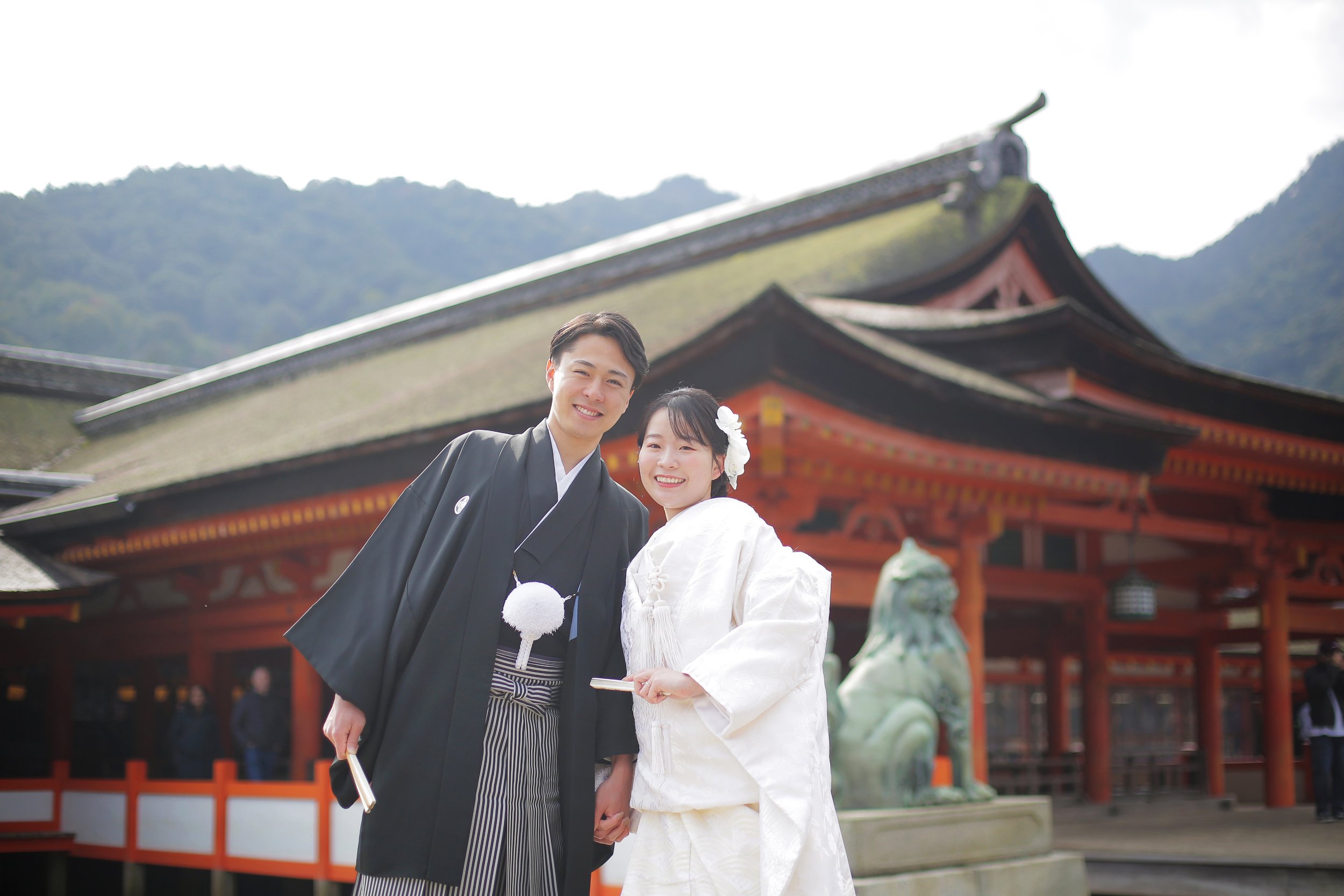 宮島フォトギャラリー｜厳島神社を背景に笑顔で並ぶ新郎新婦