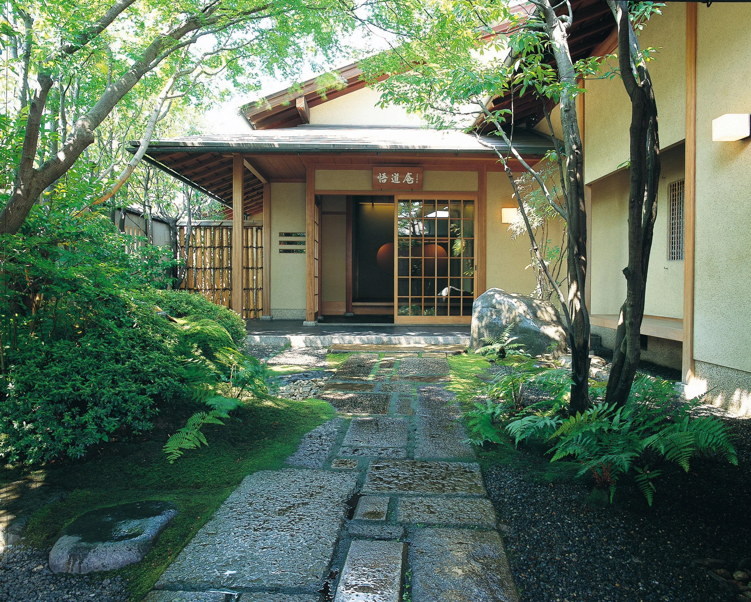 悟道庵点景 | 静かな日本の伝統的な家の入り口と庭園、石畳と緑の植物、木と建物の木枠ガラスドア、木の門と緑の木々