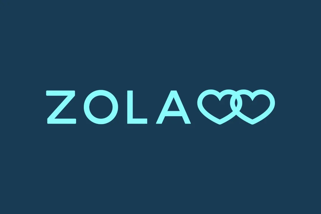 Stylized text reading 'ZOLA' with two interlocking hearts as the letter 'O' on a dark background.
