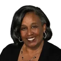 Portrait of an African American woman with shoulder-length black hair, wearing a black top and jewelry, smiling at the camera.