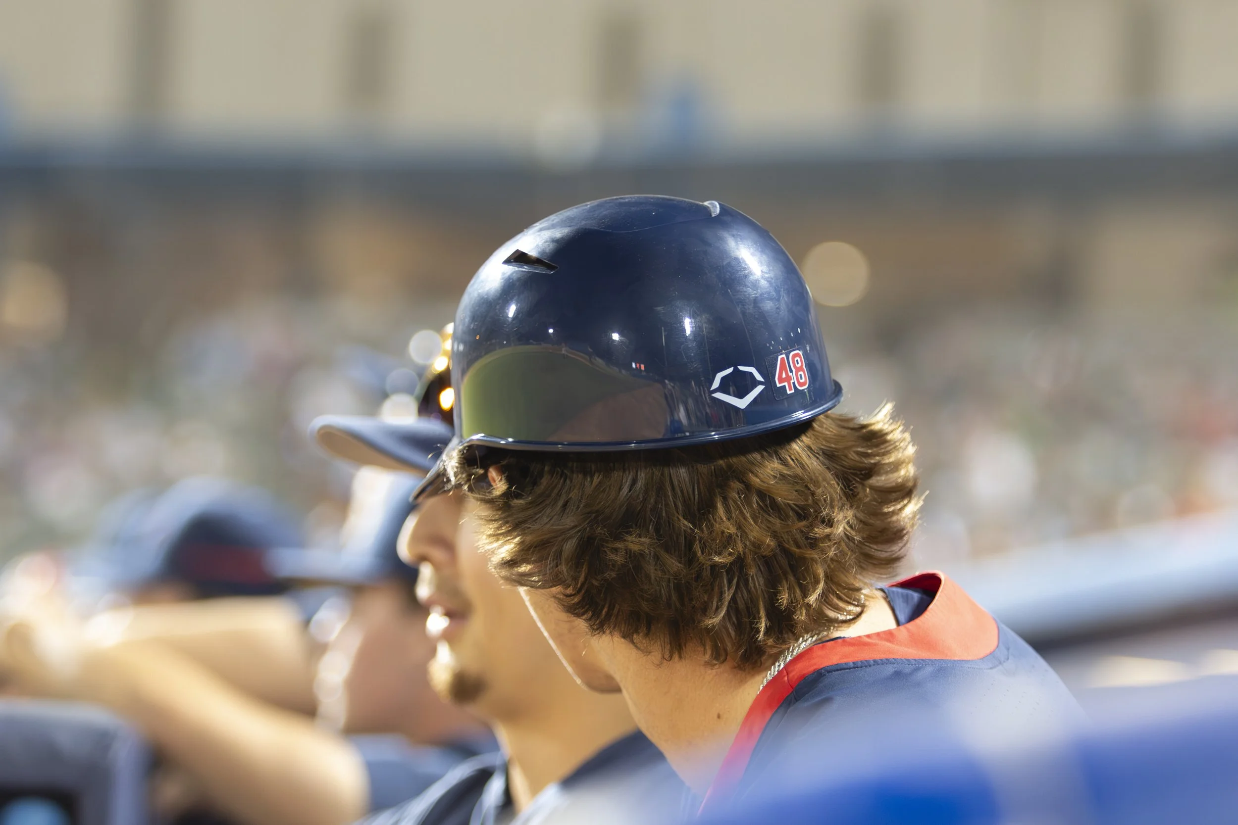 Several people wearing safety helmets, sitting outdoors.
