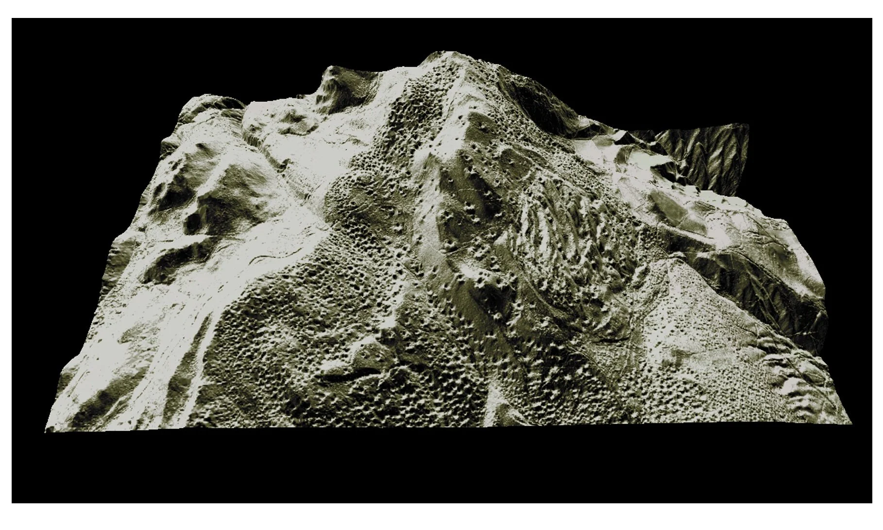 Close-up of a stone carving of a face with detailed features on a large rock surface.