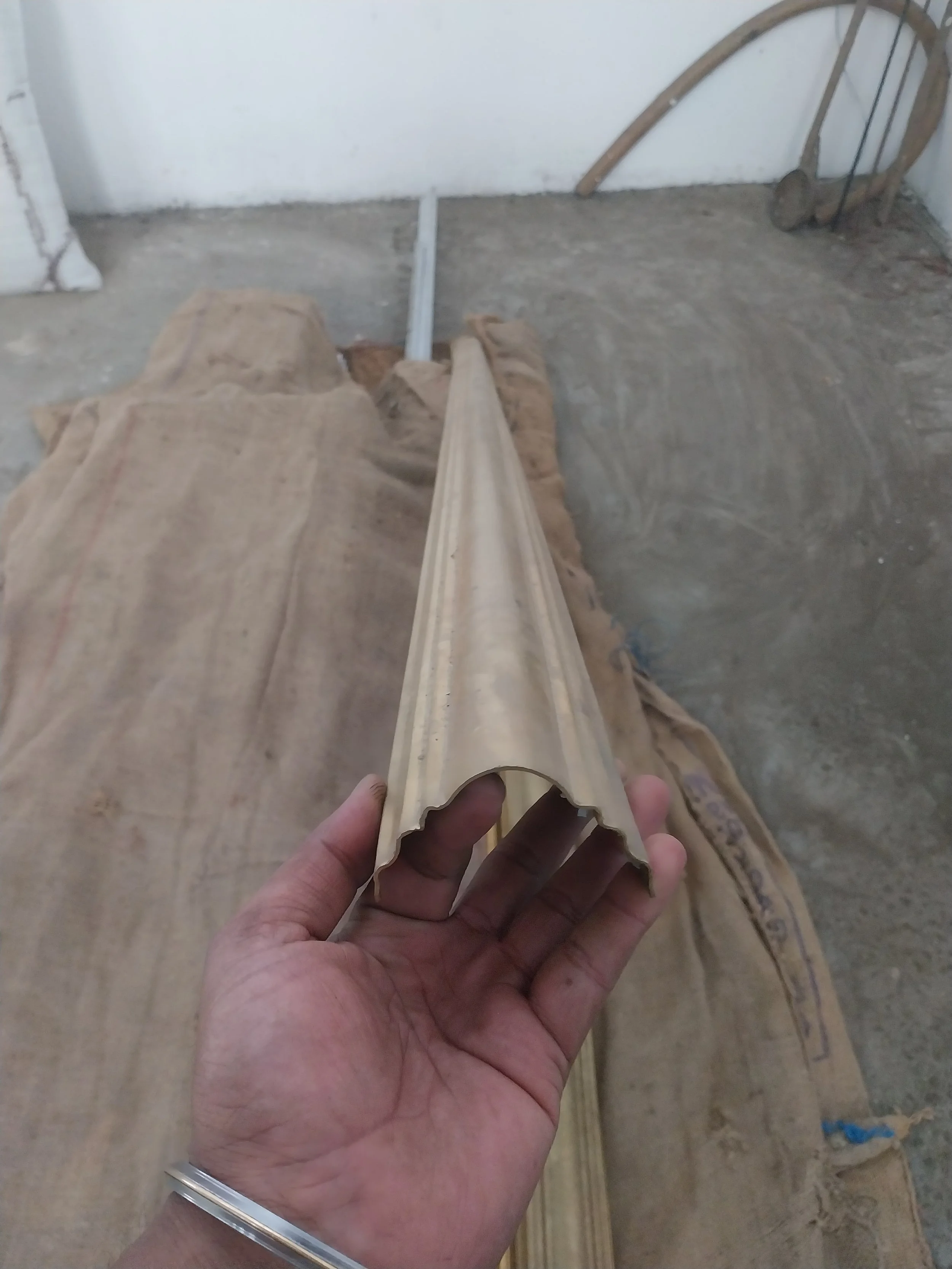 Person holding a piece of decorative brass molding.