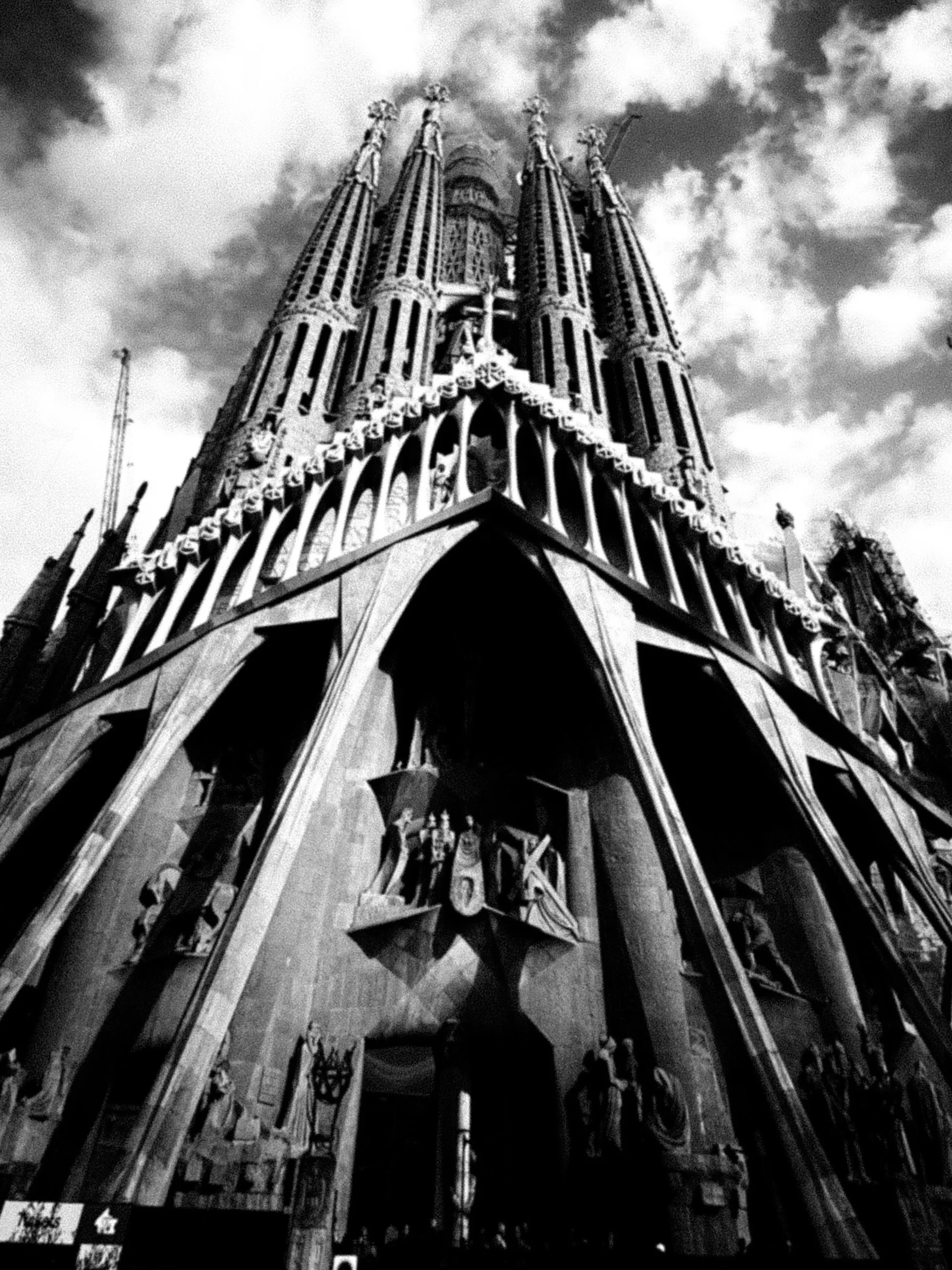 Vista frontale della Cattedrale di Santa Maria del Fiore a Firenze, in stile gotico, con dettagli architettonici elaborati e torri alte, scattata in bianco e nero.