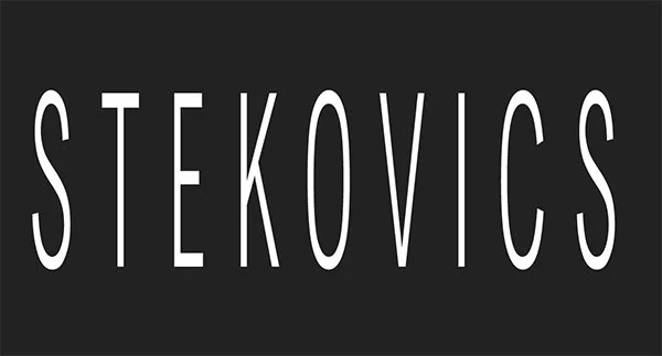 Der Name 'Stekovics' in weißen Buchstaben auf schwarzem Hintergrund.